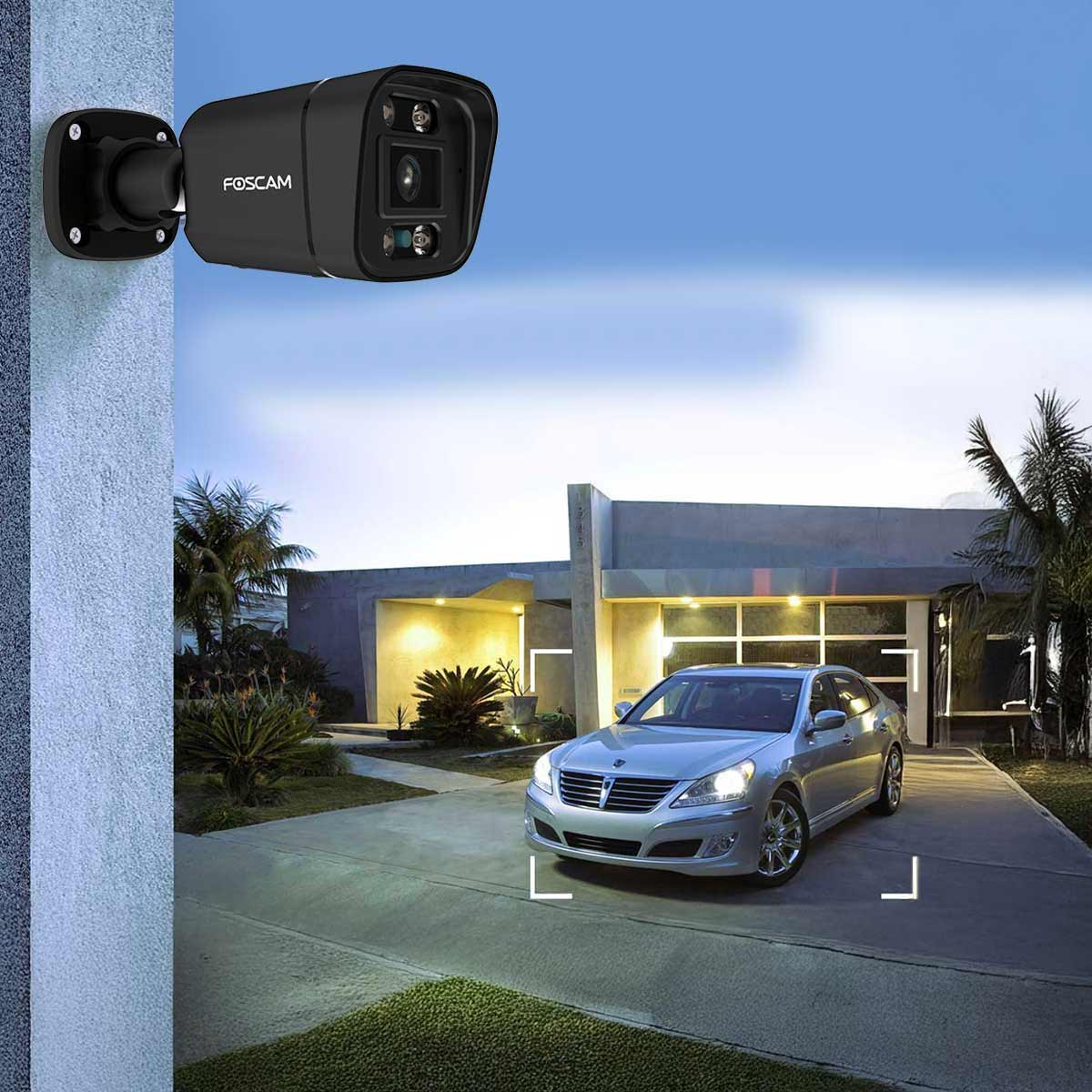 Czarna kamera bezpieczeństwa Foscam zamontowana na ścianie, z widokiem na dom i samochód.