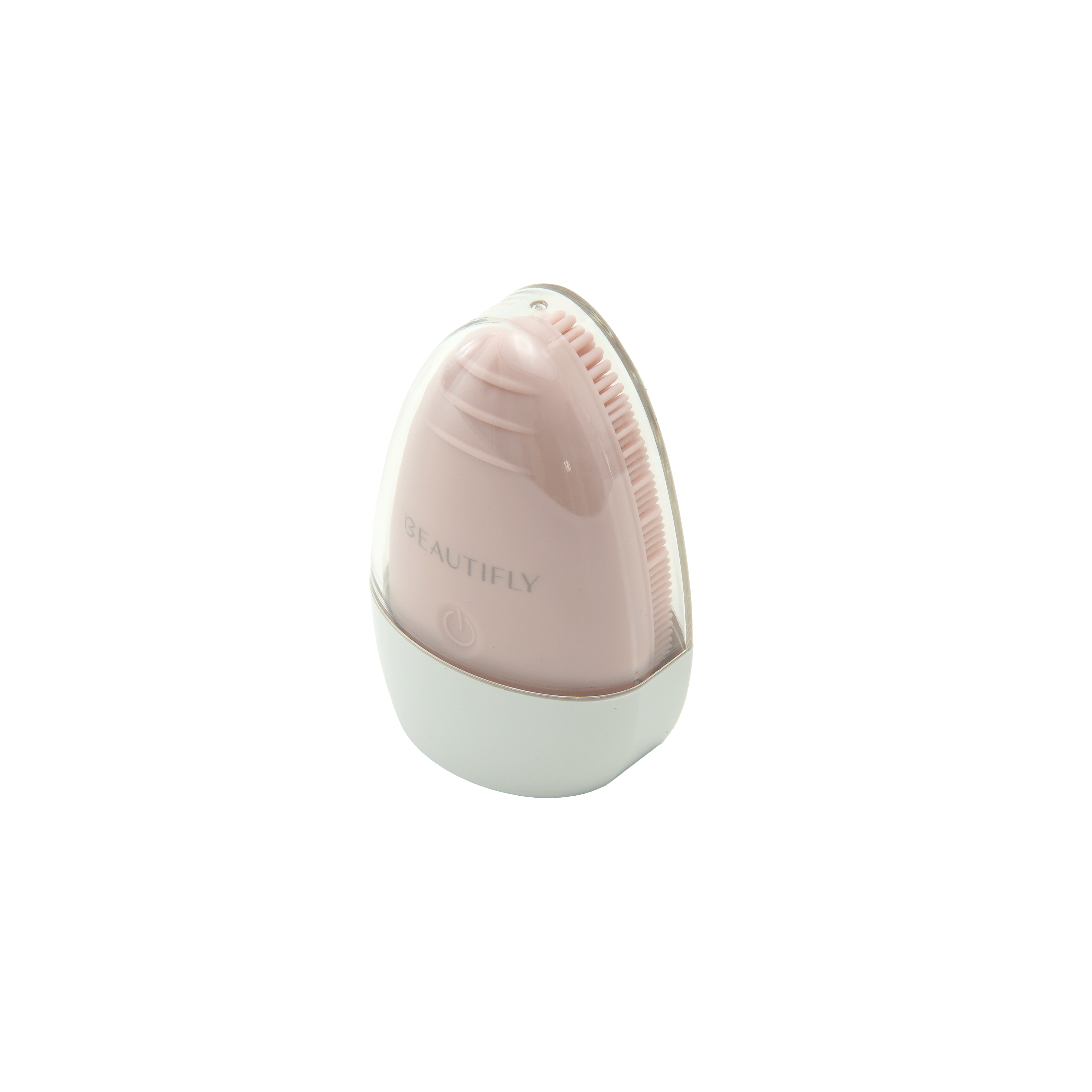 Un cepillo de limpieza facial rosa y blanco, ovalado, con tapa transparente, sobre una superficie blanca.