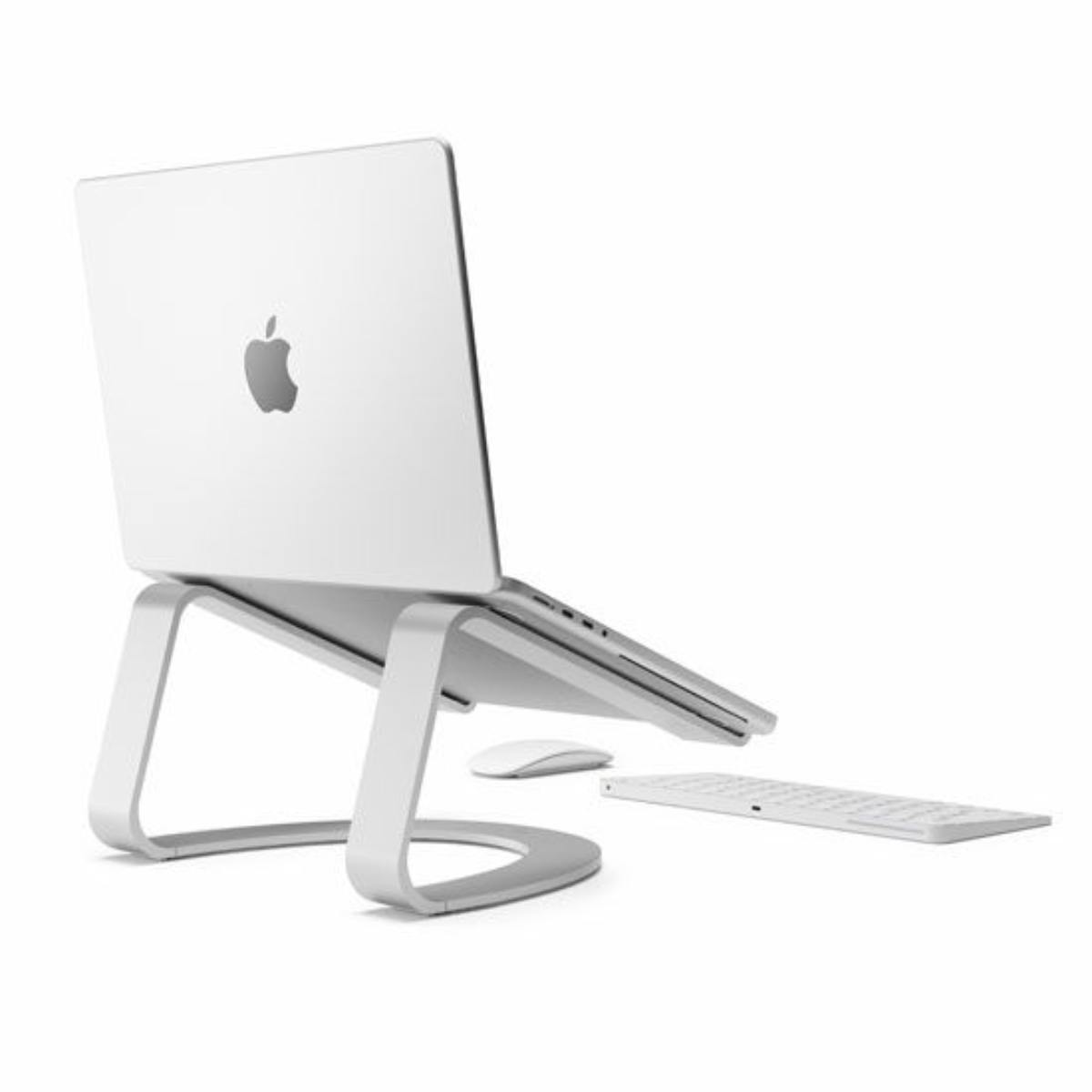 Laptop bianco su un supporto bianco con tastiera e mouse bianchi. Sfondo bianco.