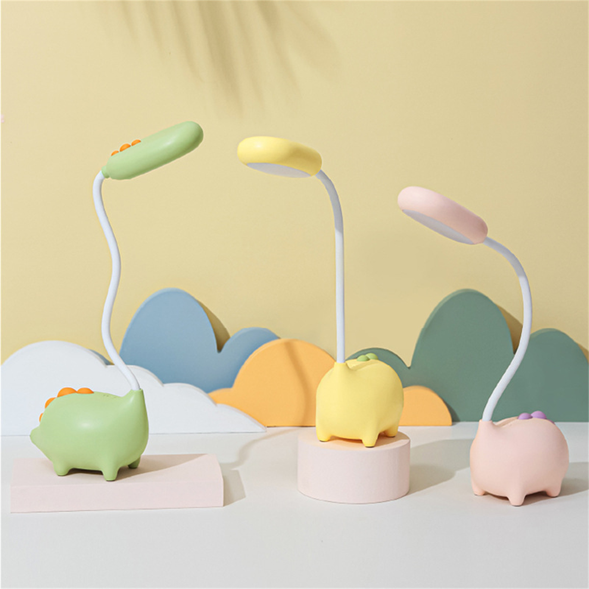 Drei Cartoon-Lampen mit Tierbasen. Grüne, gelbe und rosa Lampen mit gebogenen Hälsen.