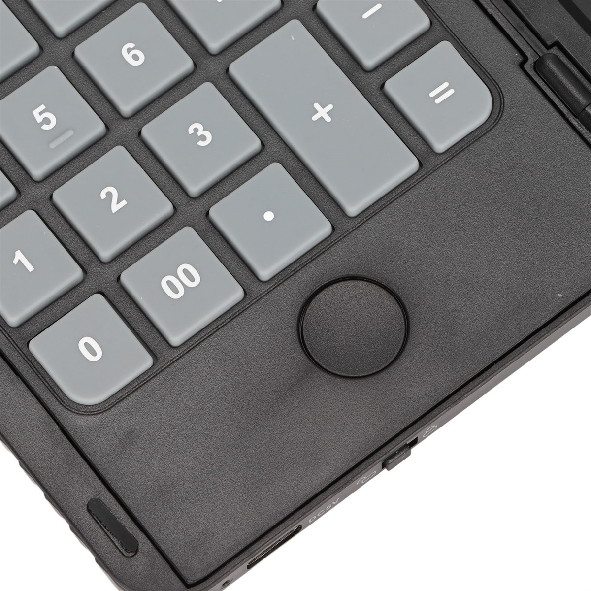 Nahaufnahme einer grau-schwarzen Tastatur mit Zifferntasten und einer kreisförmigen Taste.