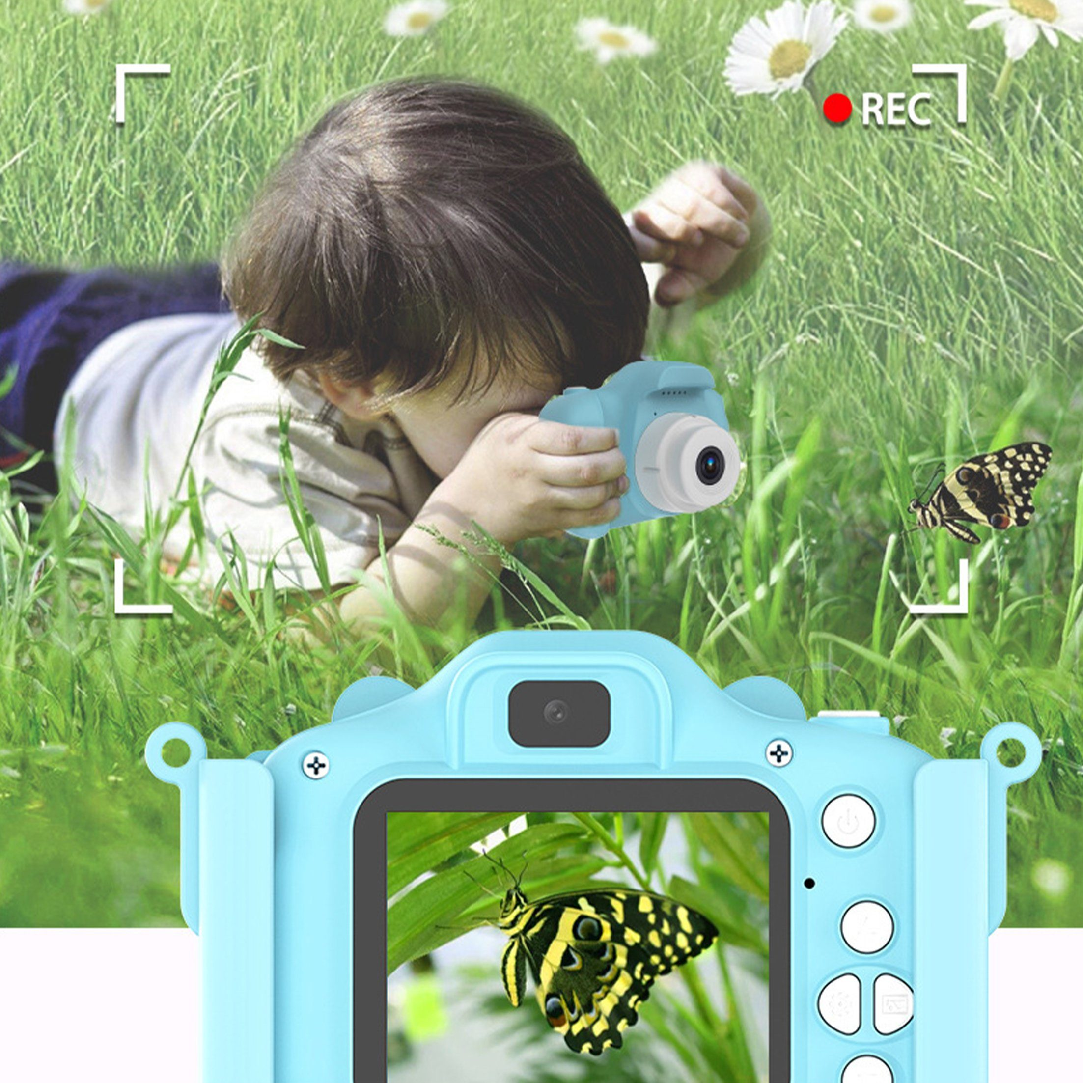 Ein Kind liegt im Gras und macht ein Foto mit einer blauen Kamera. Schmetterlinge sind sichtbar.
