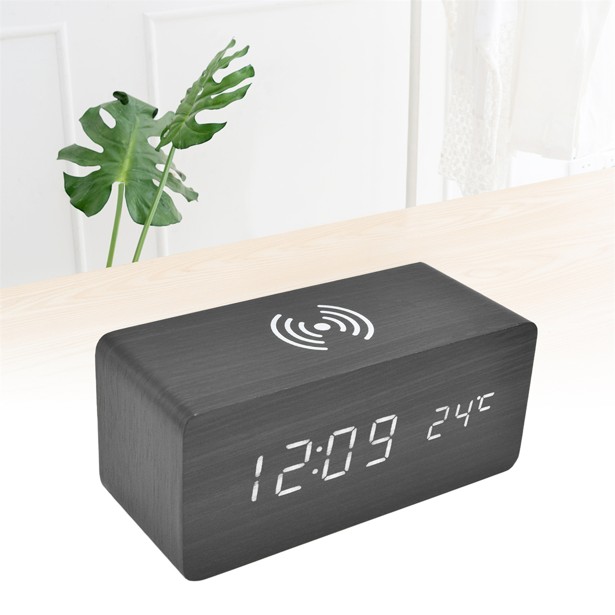 Eine schwarze Holzuhr mit digitaler Anzeige, die Zeit und Temperatur anzeigt.