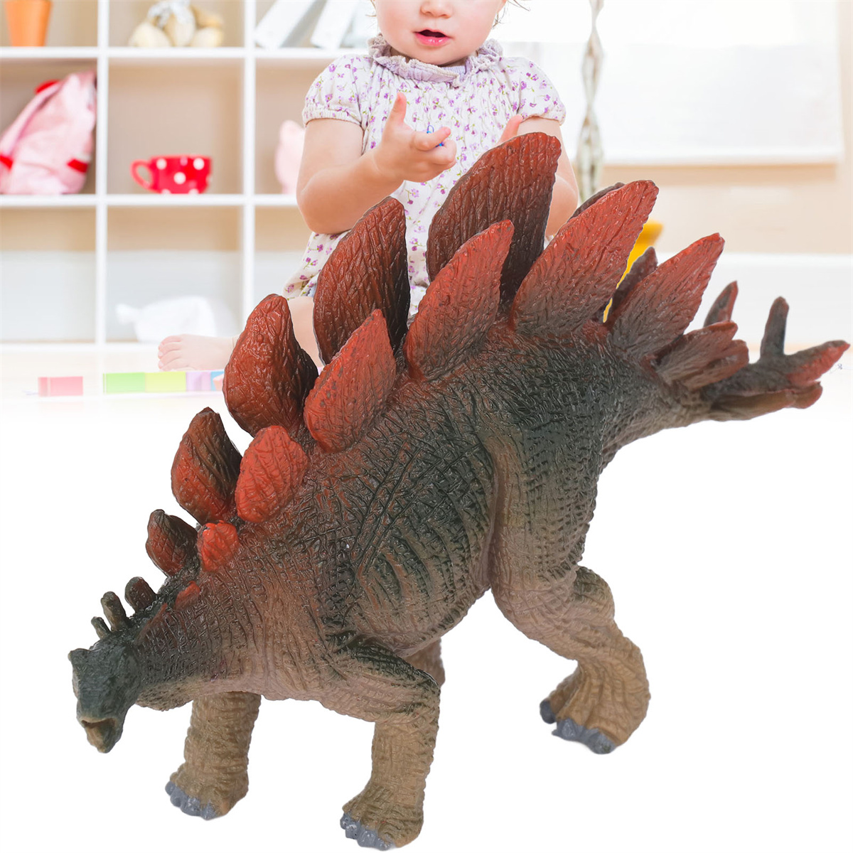 Ein Spielzeug-Dinosaurier und ein Kind. Der Dinosaurier ist braun mit roten Stacheln. Kind im Hintergrund.