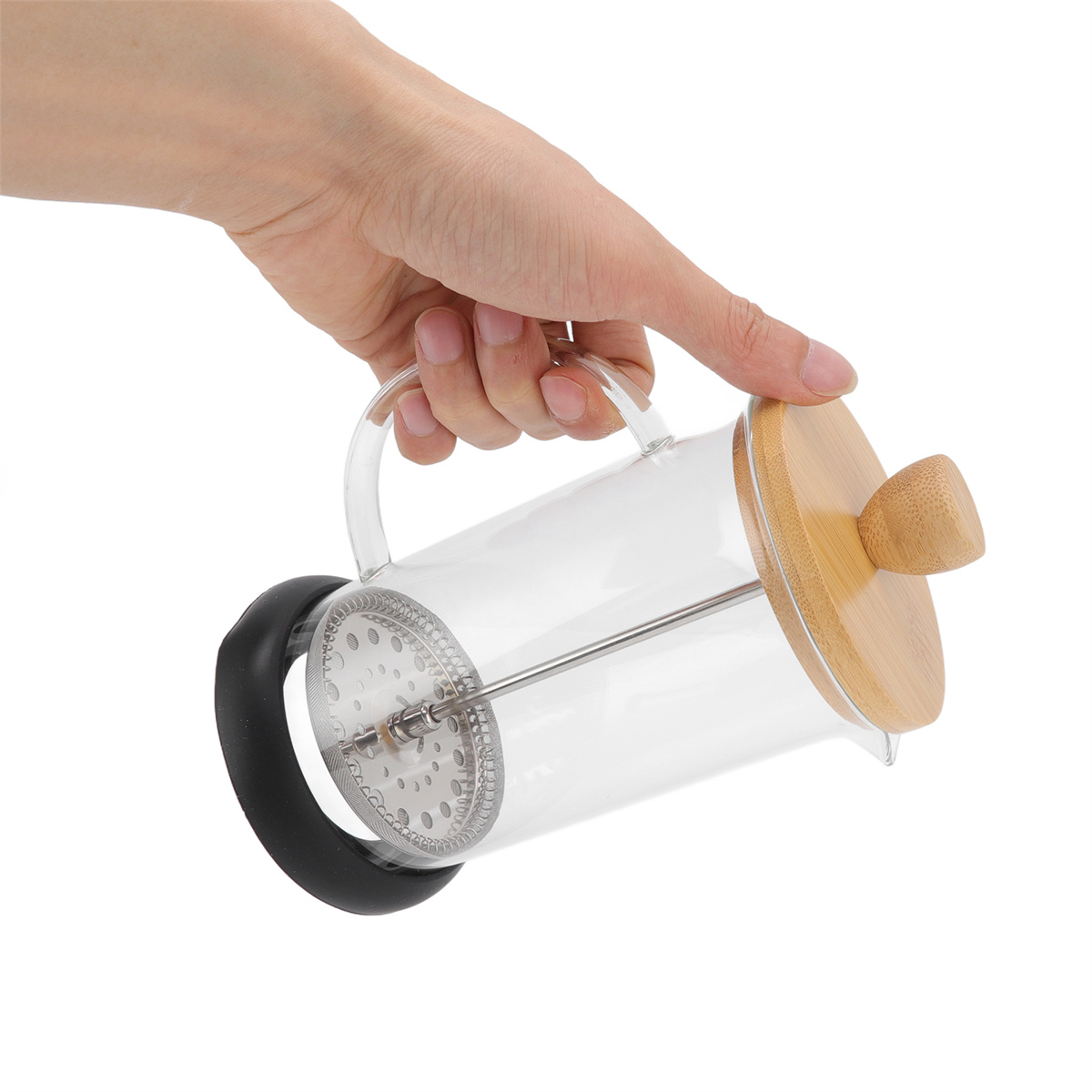 Eine Hand hält eine French Press mit Holzdeckel und transparentem Glaskörper.