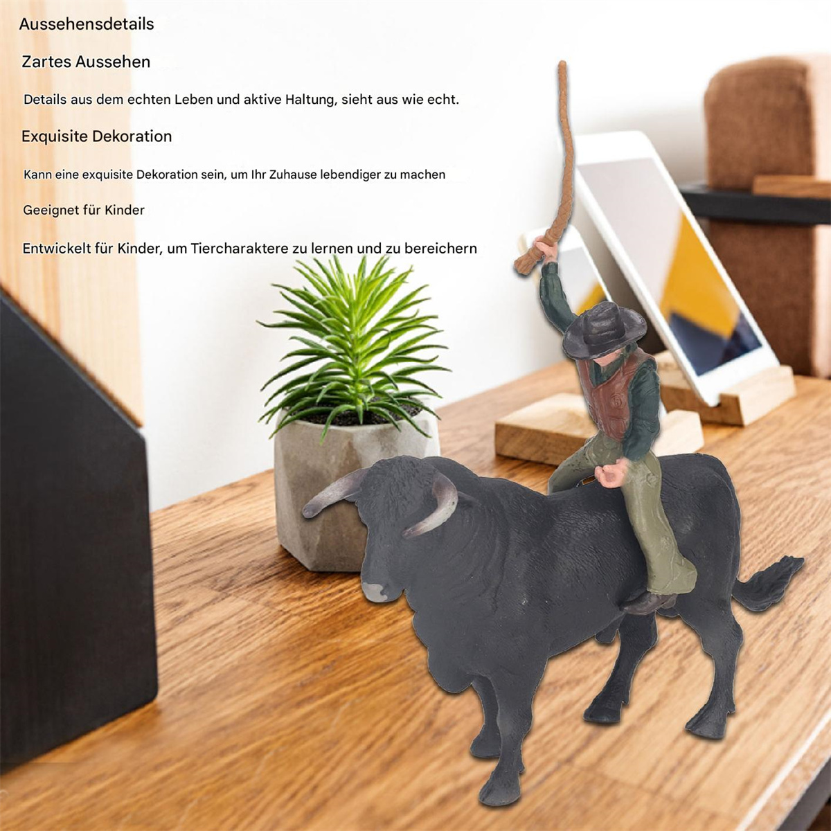 Ein Spielzeugstier mit Cowboy-Reiter auf Holztisch, mit Pflanze und Telefon.