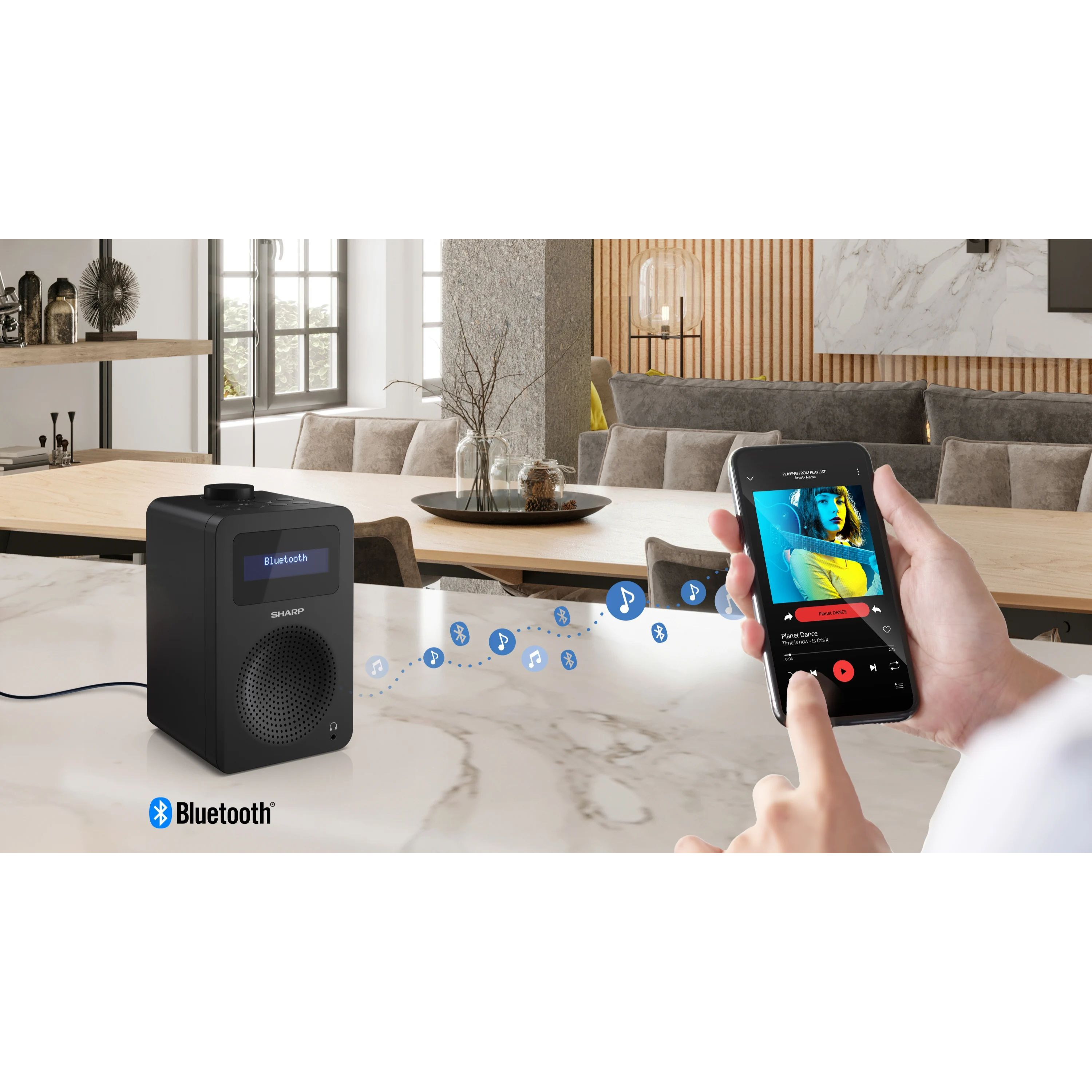 Czarny głośnik Bluetooth ze smartfonem. Ekran smartfona pokazuje aplikację muzyczną.