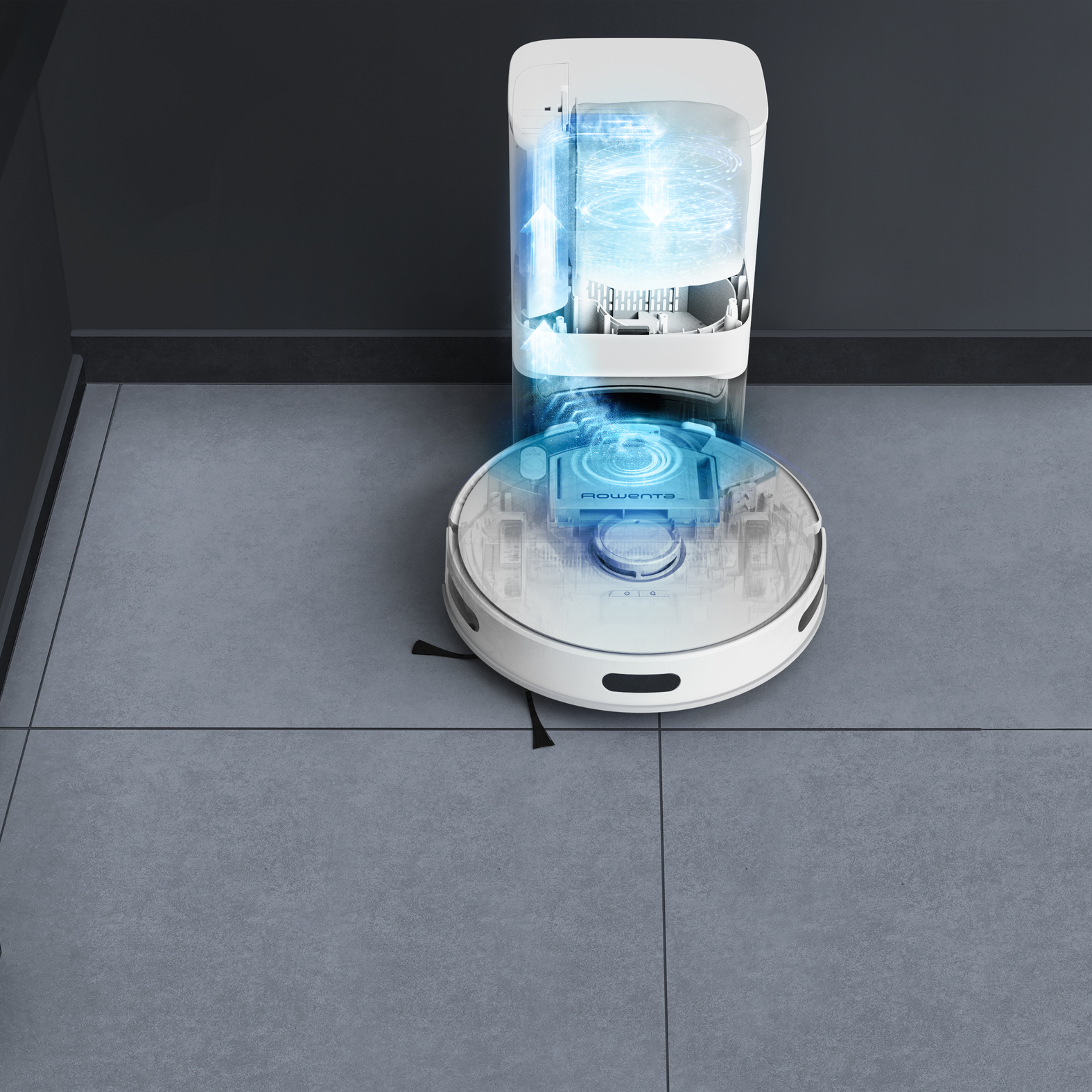 Robot aspirapolvere che pulisce un pavimento piastrellato grigio accanto a una stazione autopulente.