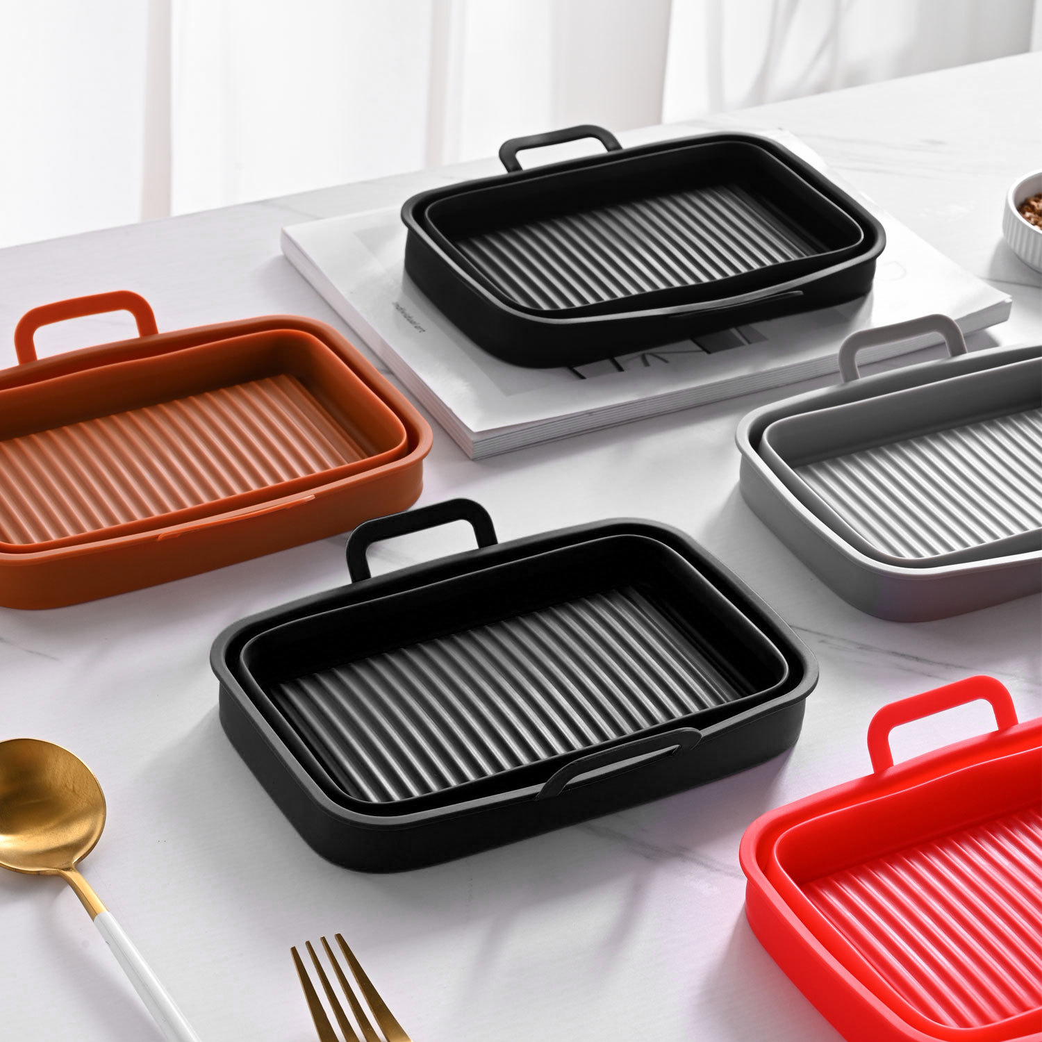 Five colorful air fryer silicone liners in various shapes and colors on a white surface.