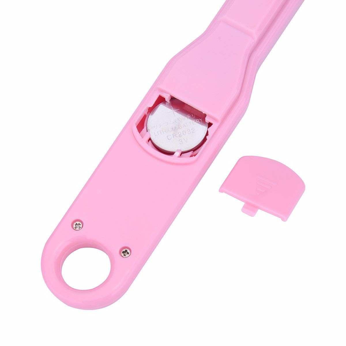 Rosa Schwangerschaftstest mit geöffnetem Batteriefach, Knopfzelle sichtbar. Der Deckel liegt daneben.