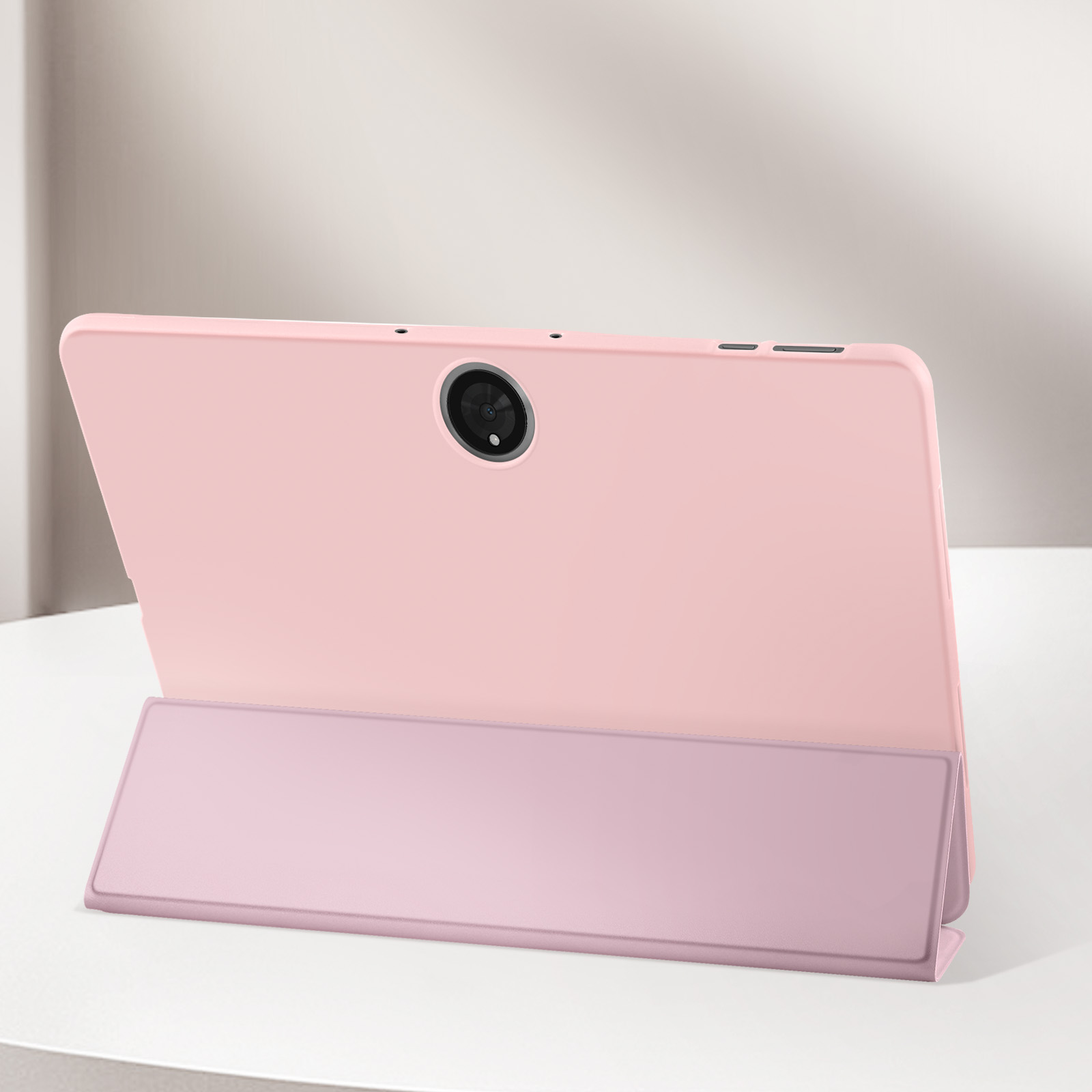 Tableta rosa con una funda rosa apoyada en una superficie blanca, vista trasera.