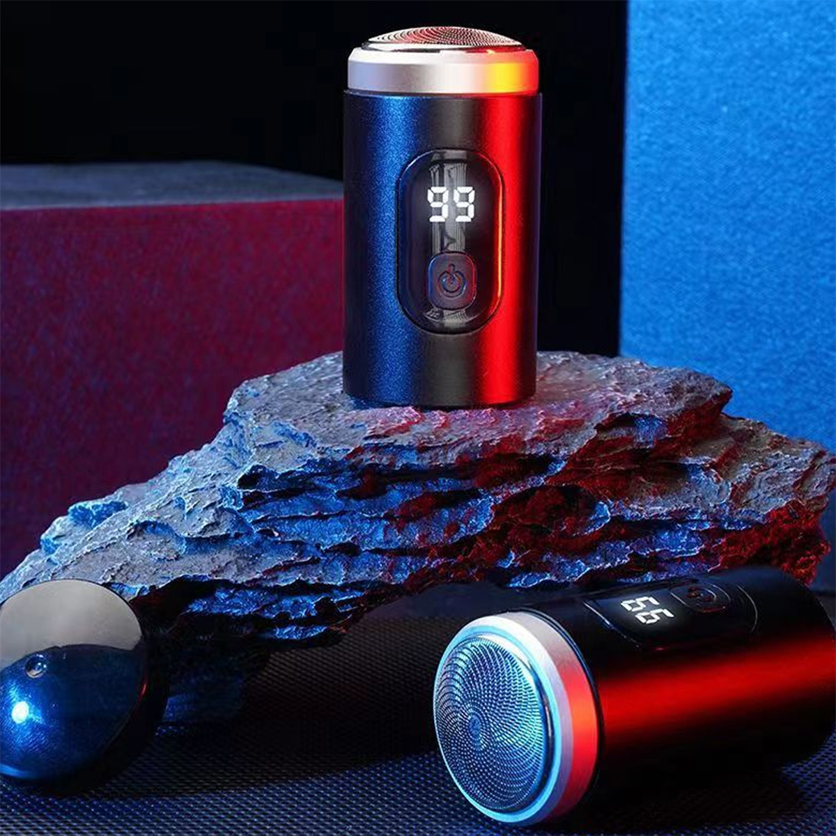 Zwei schwarze Rasierer, einer stehend, einer liegend, mit blauem und rot beleuchtetem Hintergrund.