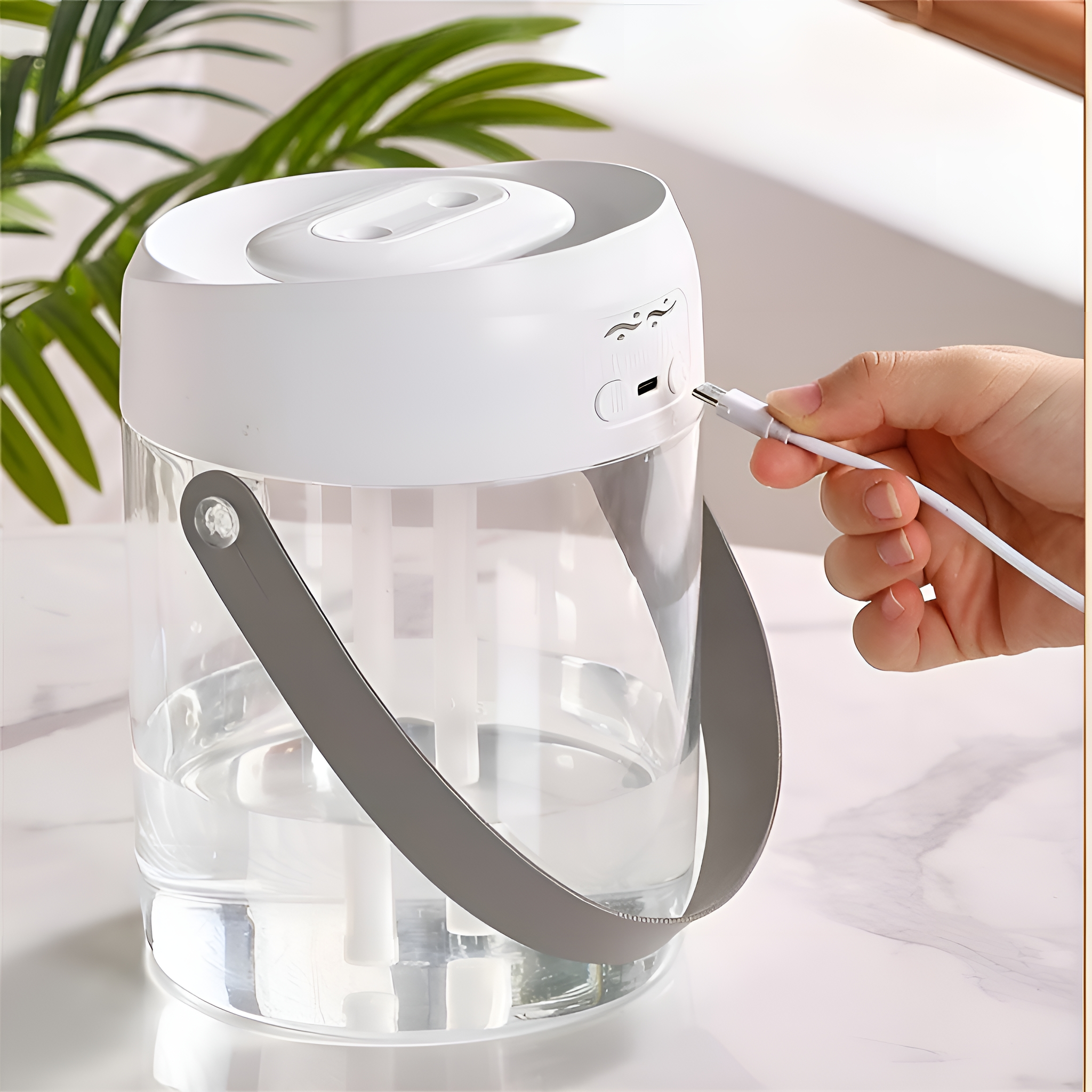 Eine Hand steckt ein weißes USB-Kabel in einen weißen, transparenten Luftbefeuchter mit Wasser gefüllt.