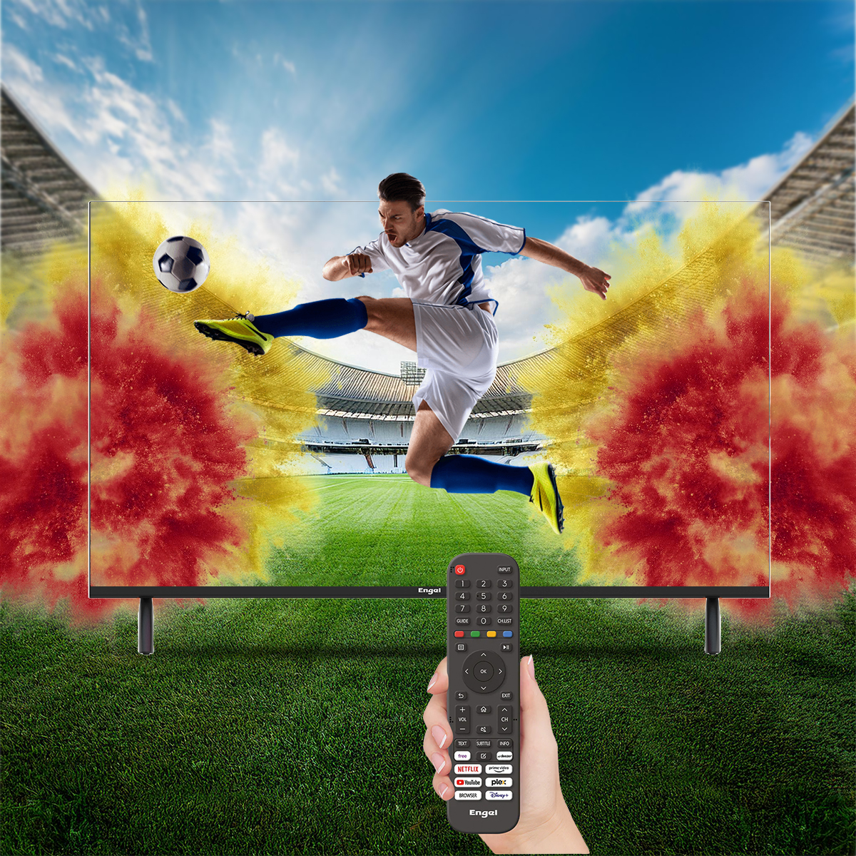 Jugador de fútbol pateando un balón frente a una pantalla de TV. Control remoto en mano.