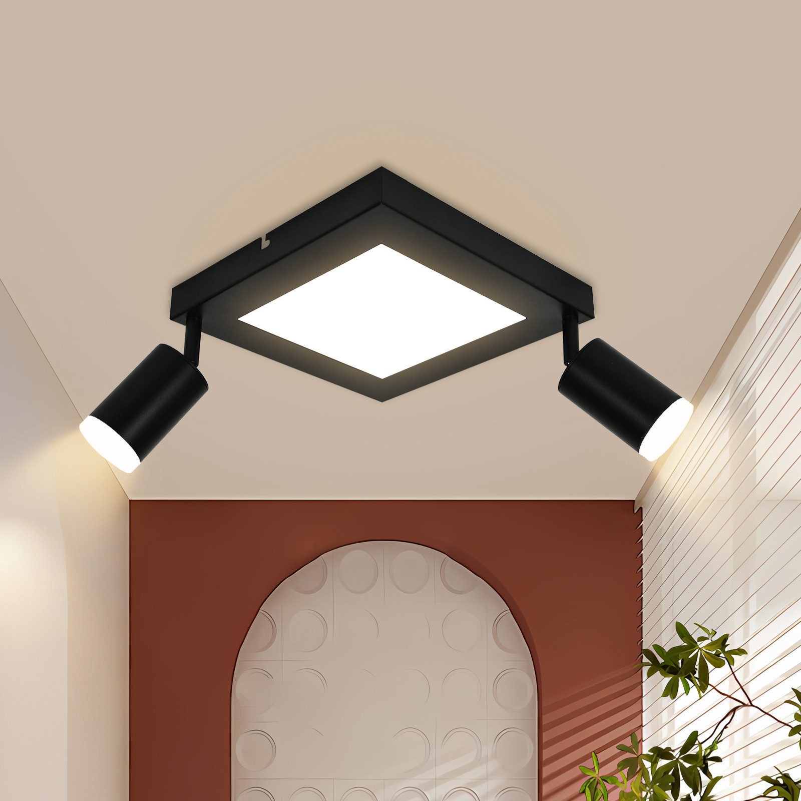 Faretto da soffitto nero con due luci regolabili e un pannello quadrato centrale, contro un soffitto bianco.