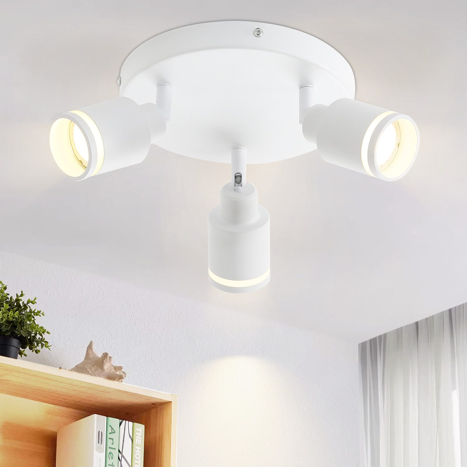 Un apparecchio di illuminazione a soffitto con tre faretti bianchi.