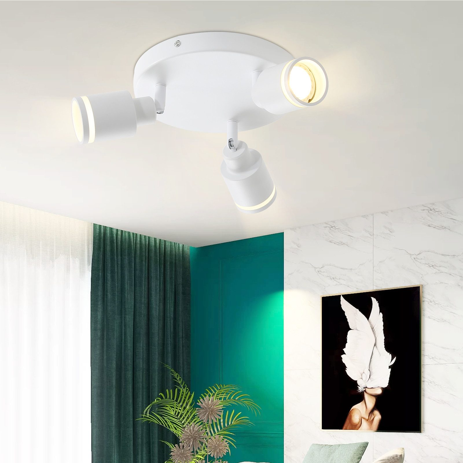 Faretti a soffitto bianchi con tre luci e soffitto bianco. Tendine verdi a sinistra.