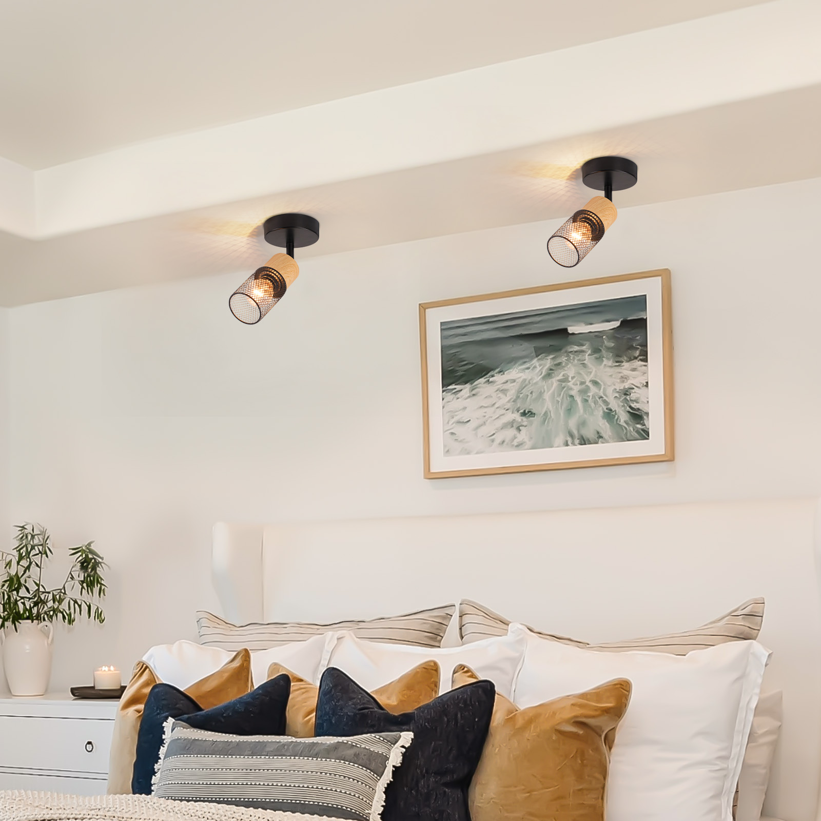 Camera da letto con due faretti sul soffitto, un letto e una cornice sulla parete.