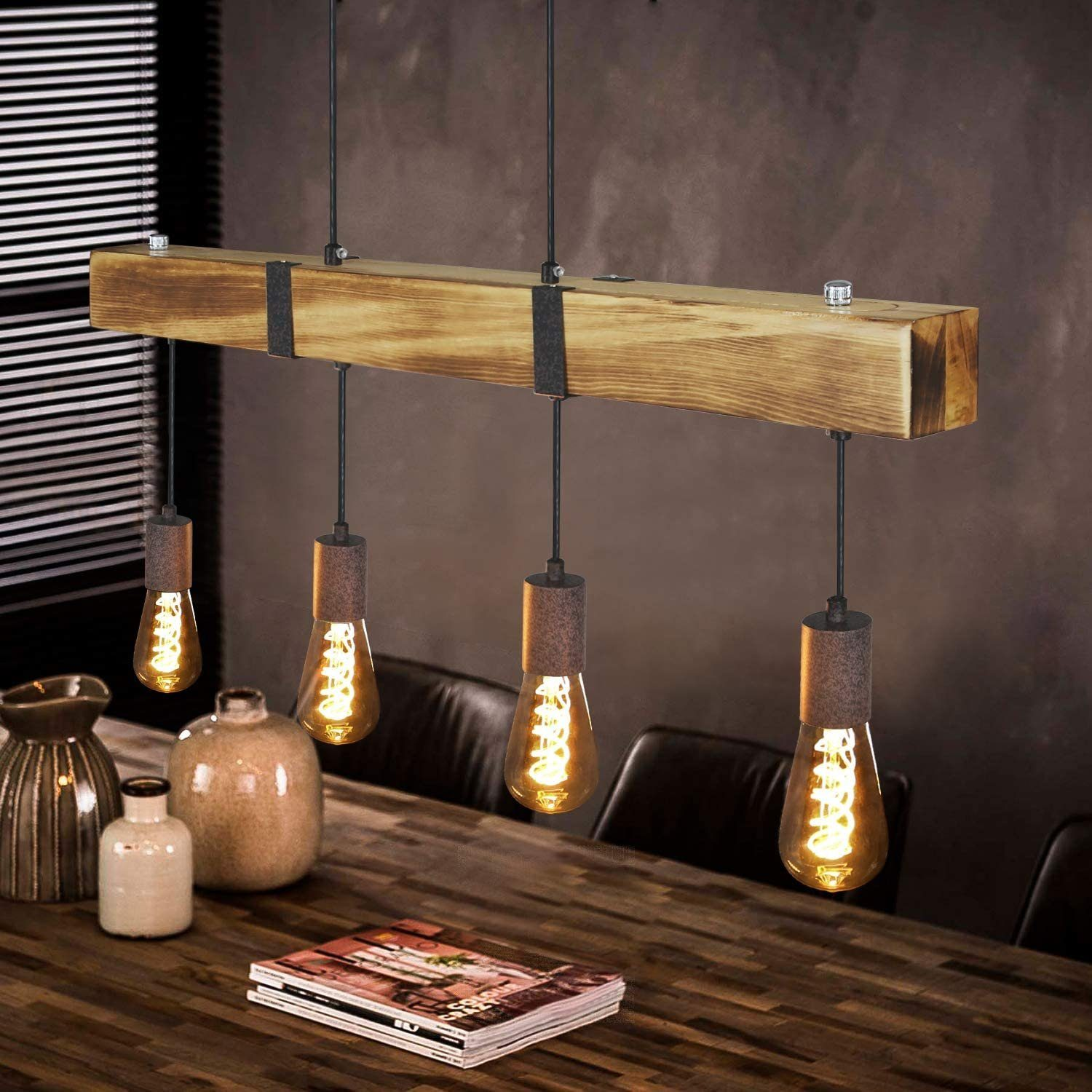 Una trave di legno con 4 lampadine a sospensione. Le lampadine sono accese e la stanza ha un'atmosfera scura e accogliente.