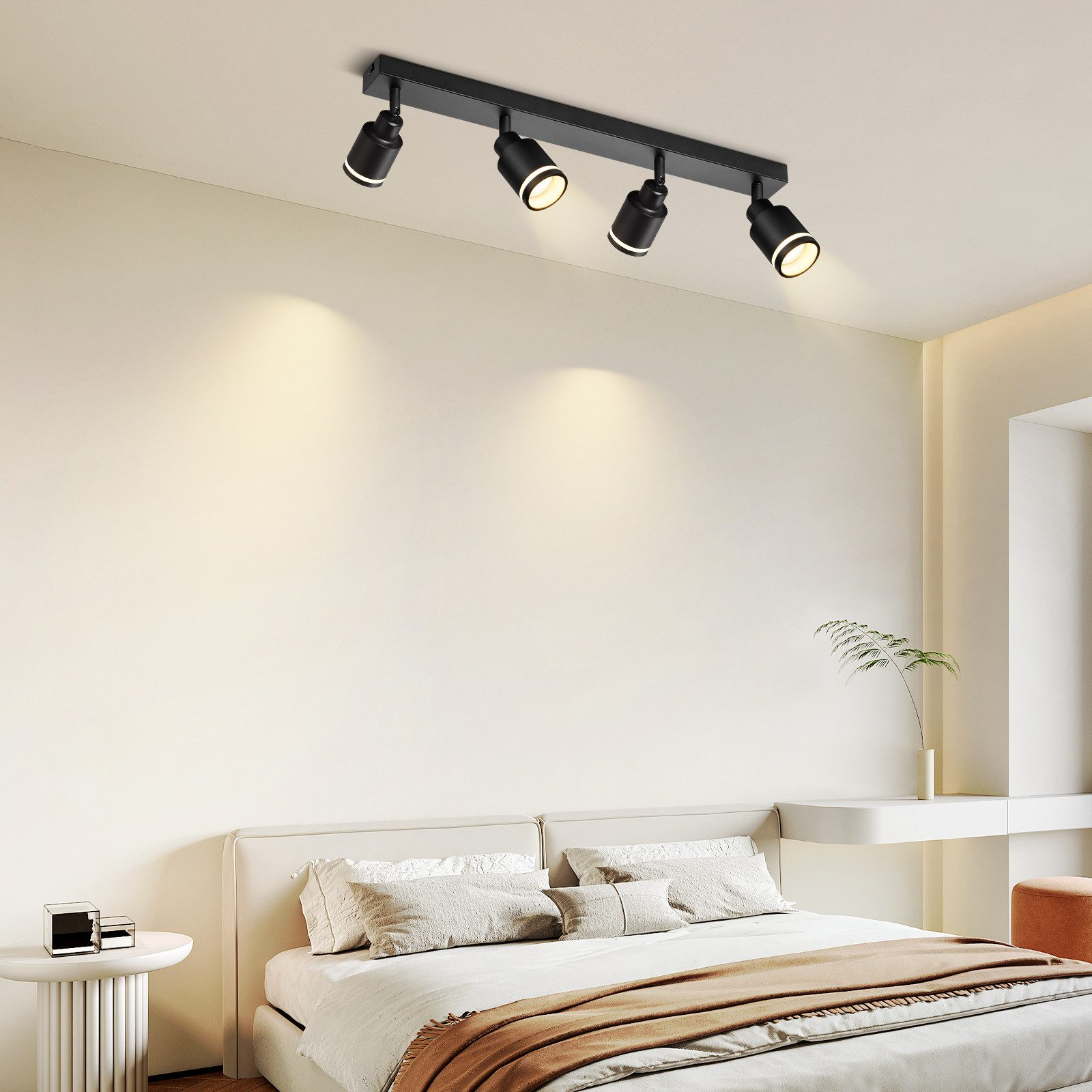 Una scena di camera da letto con un'apparecchio di illuminazione a binario nero sul soffitto e un letto in primo piano.