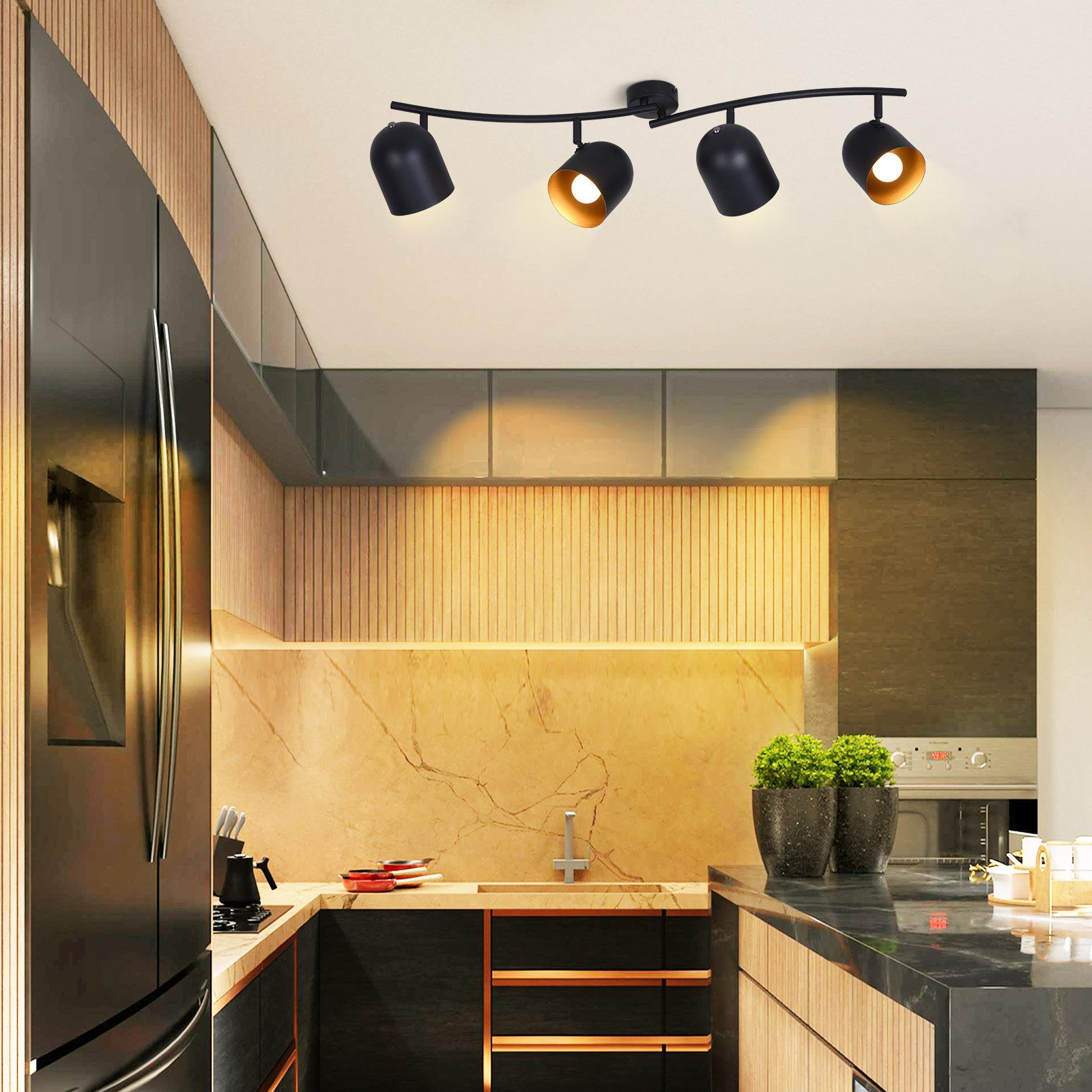 Cucina con faretti neri e oro. Mobili in legno e alzatina effetto marmo.
