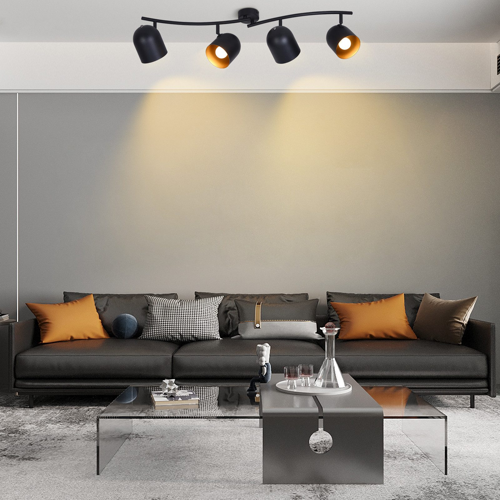 Un soggiorno con un divano nero, un tavolino in vetro e un'illuminazione a binario sul soffitto.