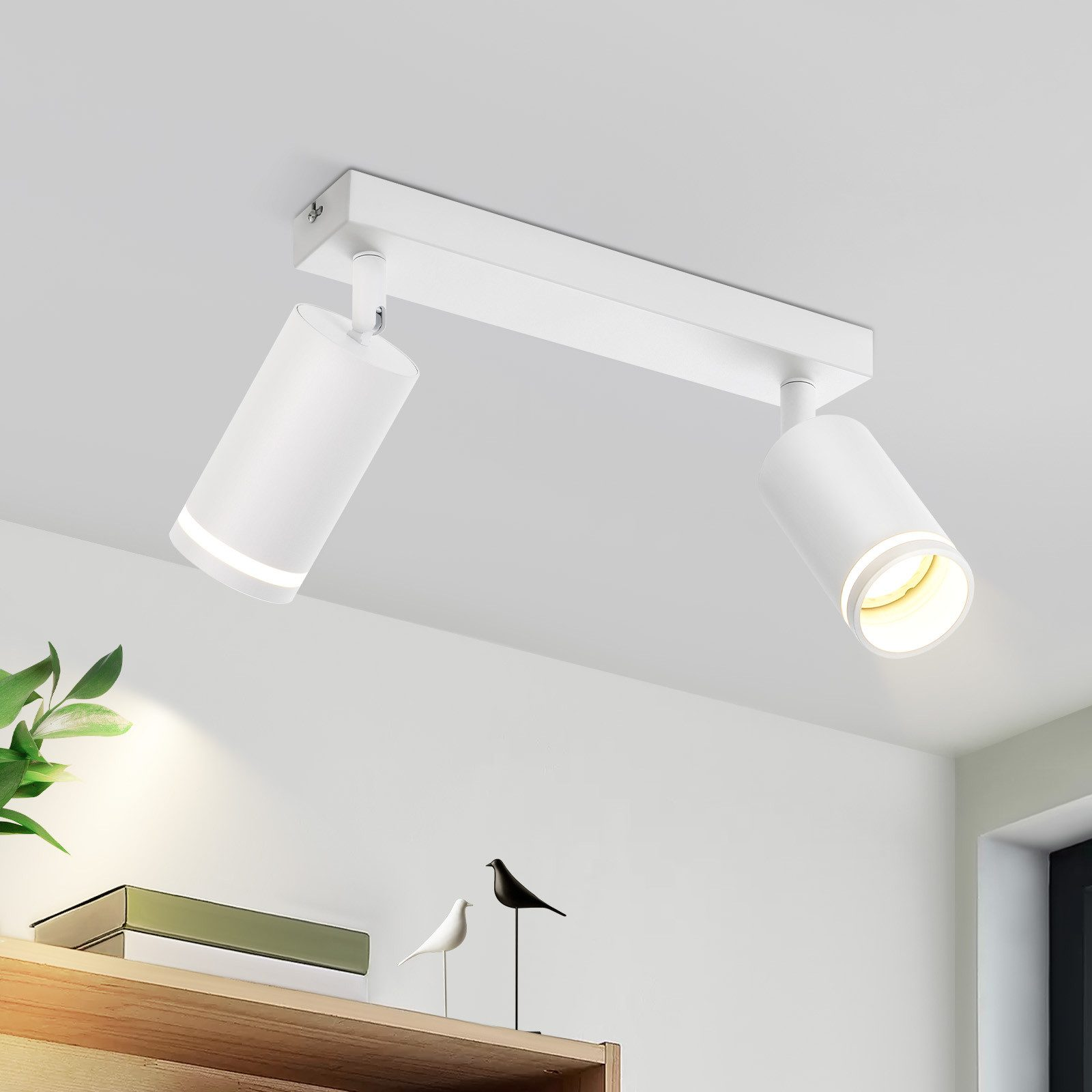 Faretti da soffitto bianchi. Due luci cilindriche su una barra bianca, contro il soffitto bianco.