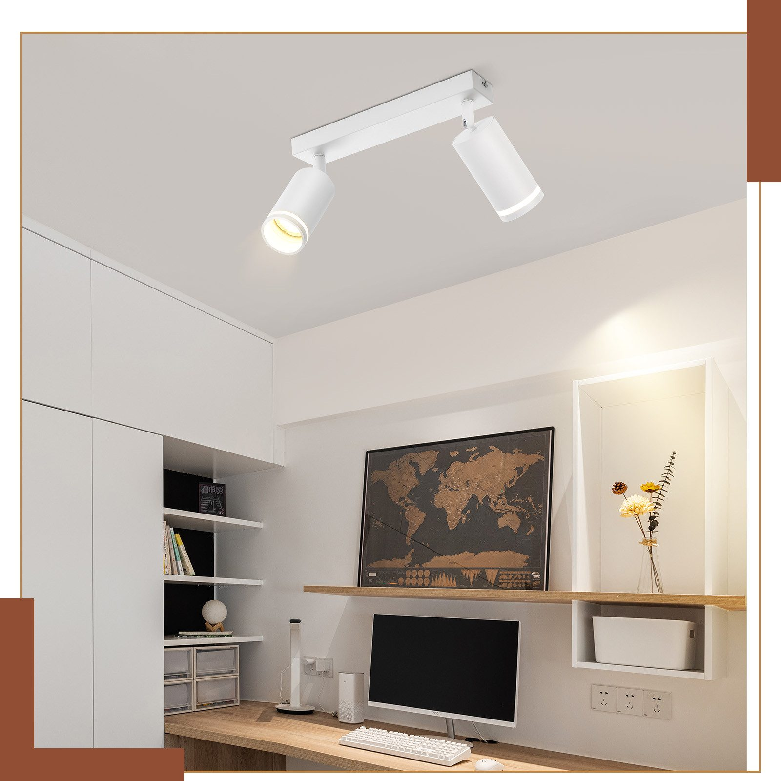 Białe reflektory sufitowe. Biurko z monitorem, mapą świata i półkami w pokoju.