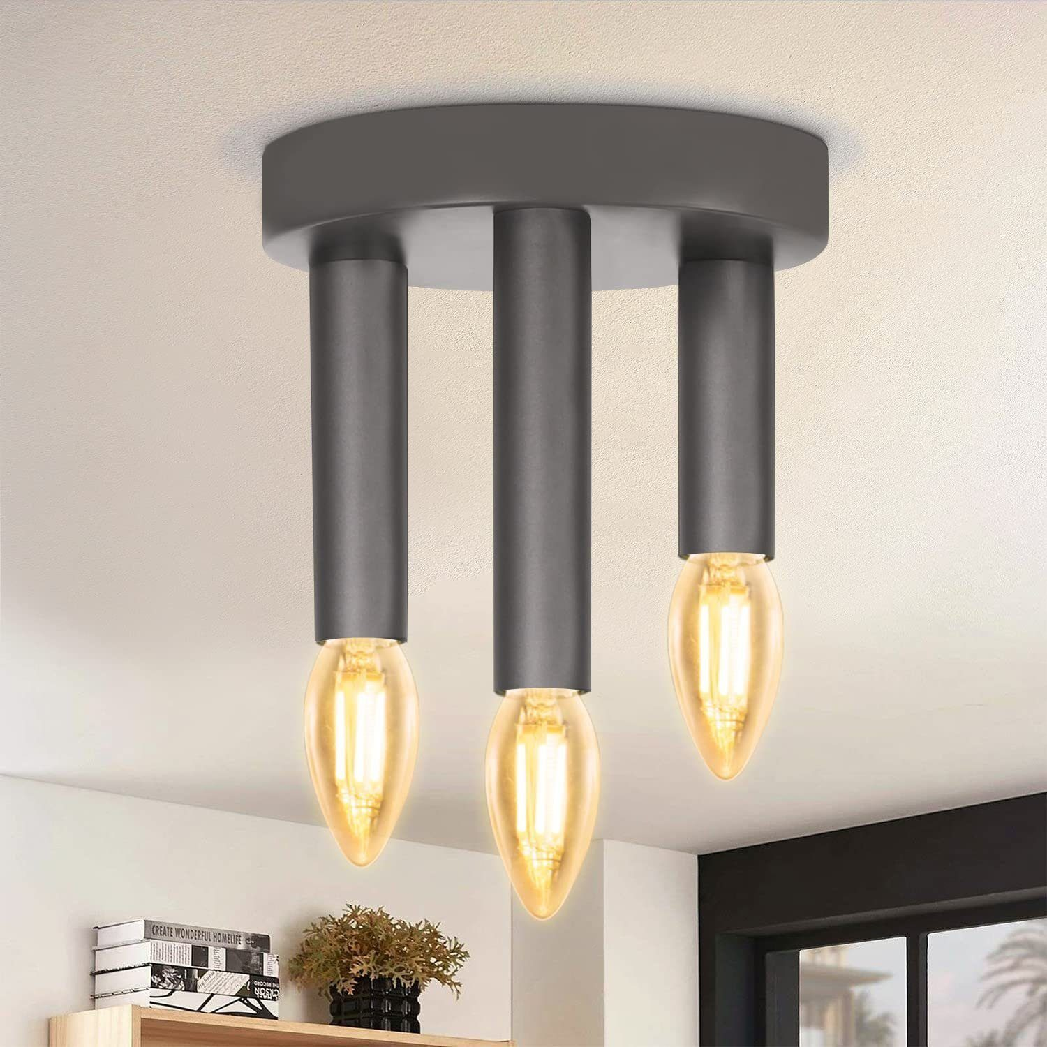 Tre lampade a sospensione con lampadine Edison, montate a soffitto. Il soffitto è bianco.