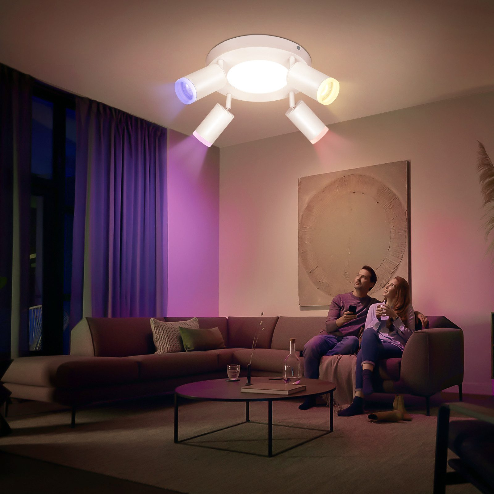 Una coppia in una stanza con una luce a soffitto, e raggi rosa e gialli che illuminano.