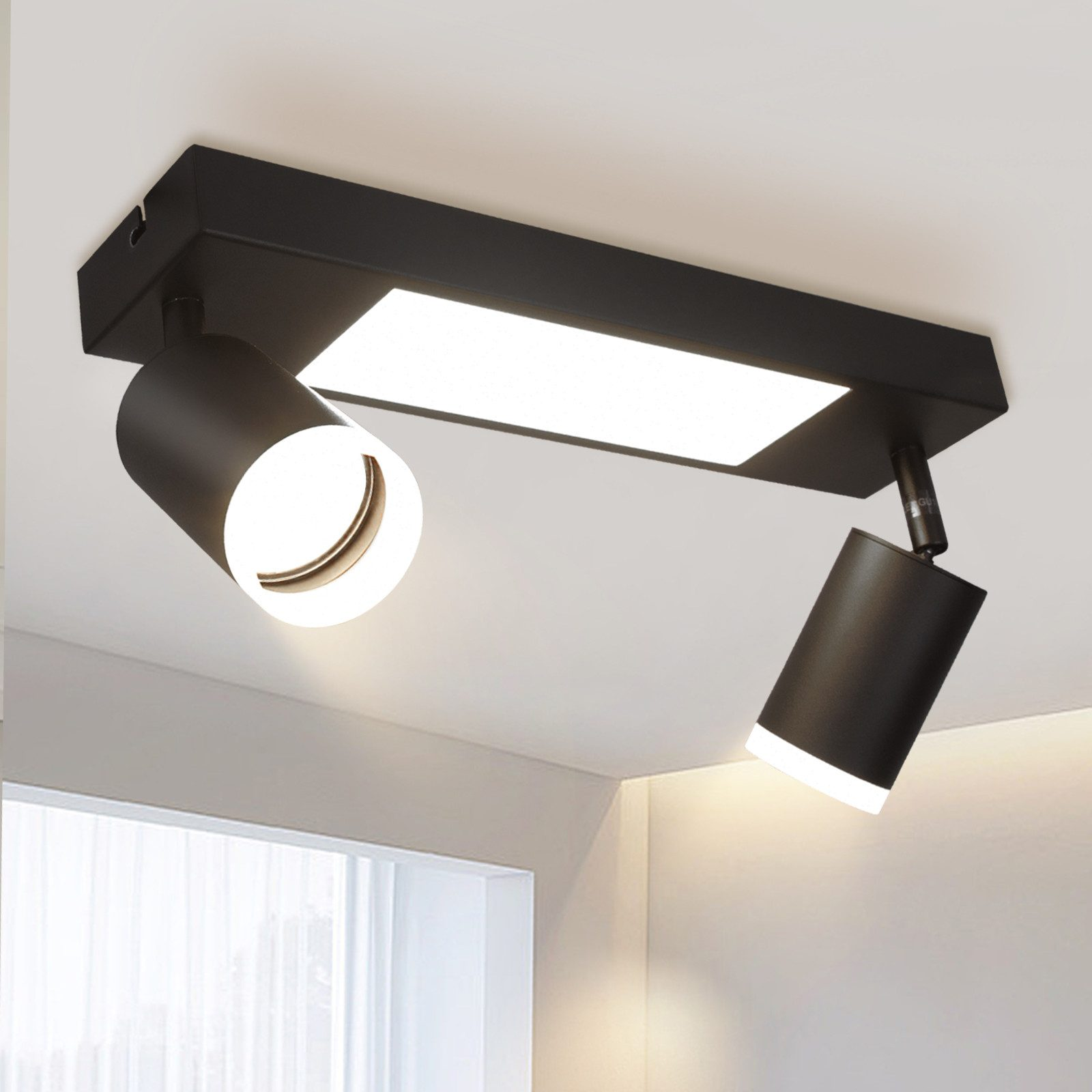 Due faretti neri su una base rettangolare nera, attaccati a un soffitto bianco.