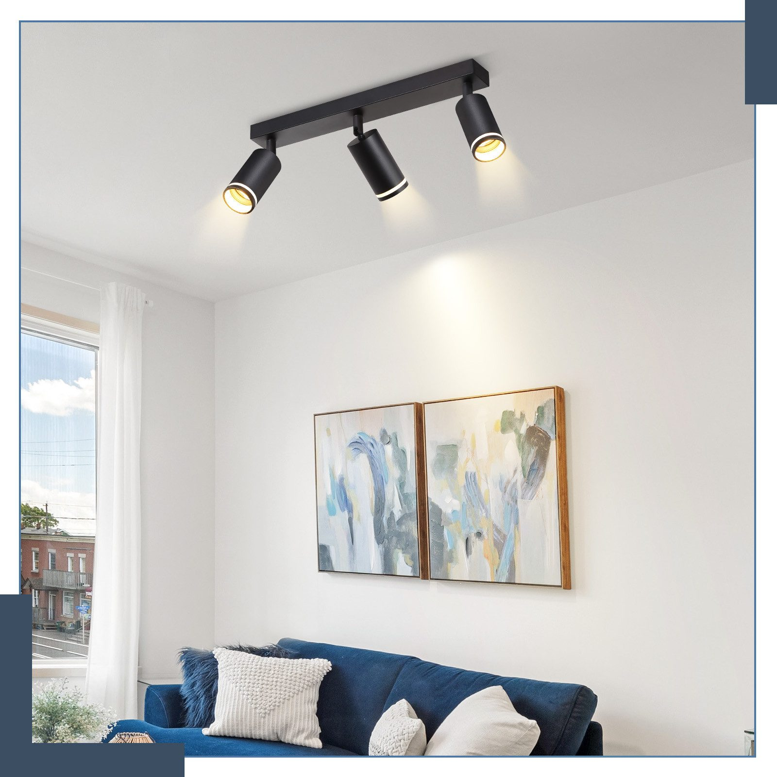 Un soggiorno moderno con divano blu, pareti bianche e un sistema di illuminazione a binario.