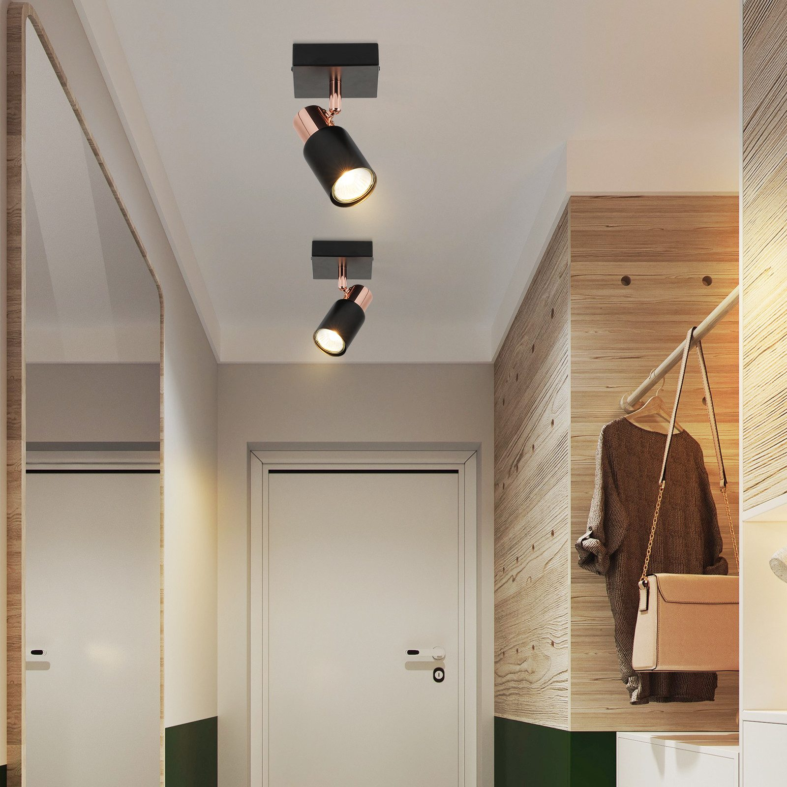 Due faretti neri e oro rosa montati su un soffitto bianco, sopra un corridoio con una porta bianca.
