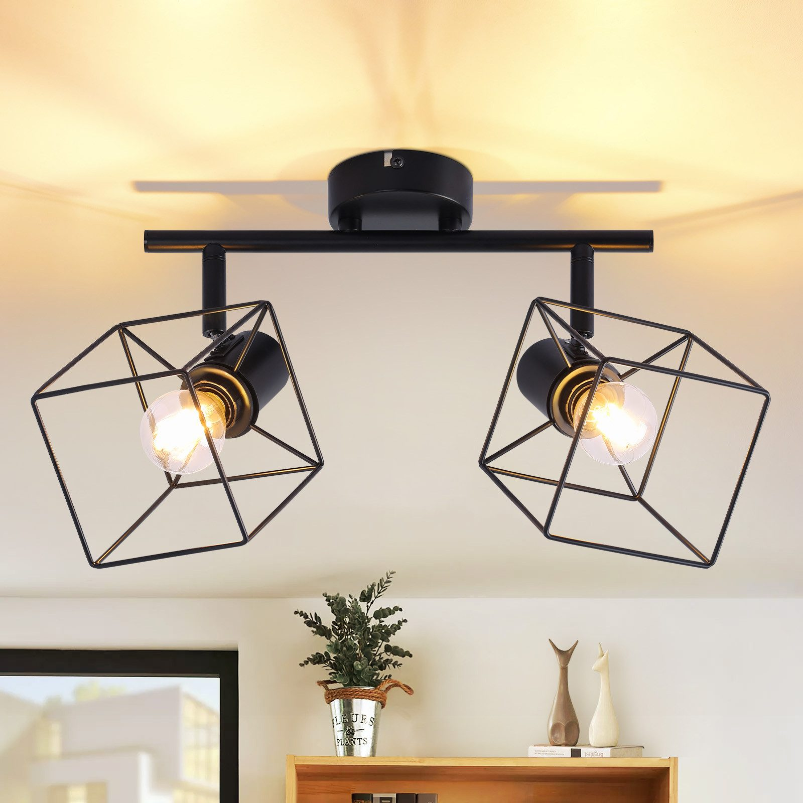 Due luci nere di forma geometrica appese al soffitto. Sono attaccate a un binario nero.