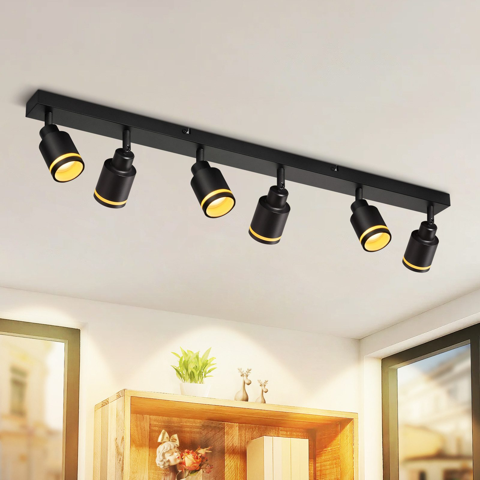 Faretti da soffitto neri, sei in fila, con luce gialla.