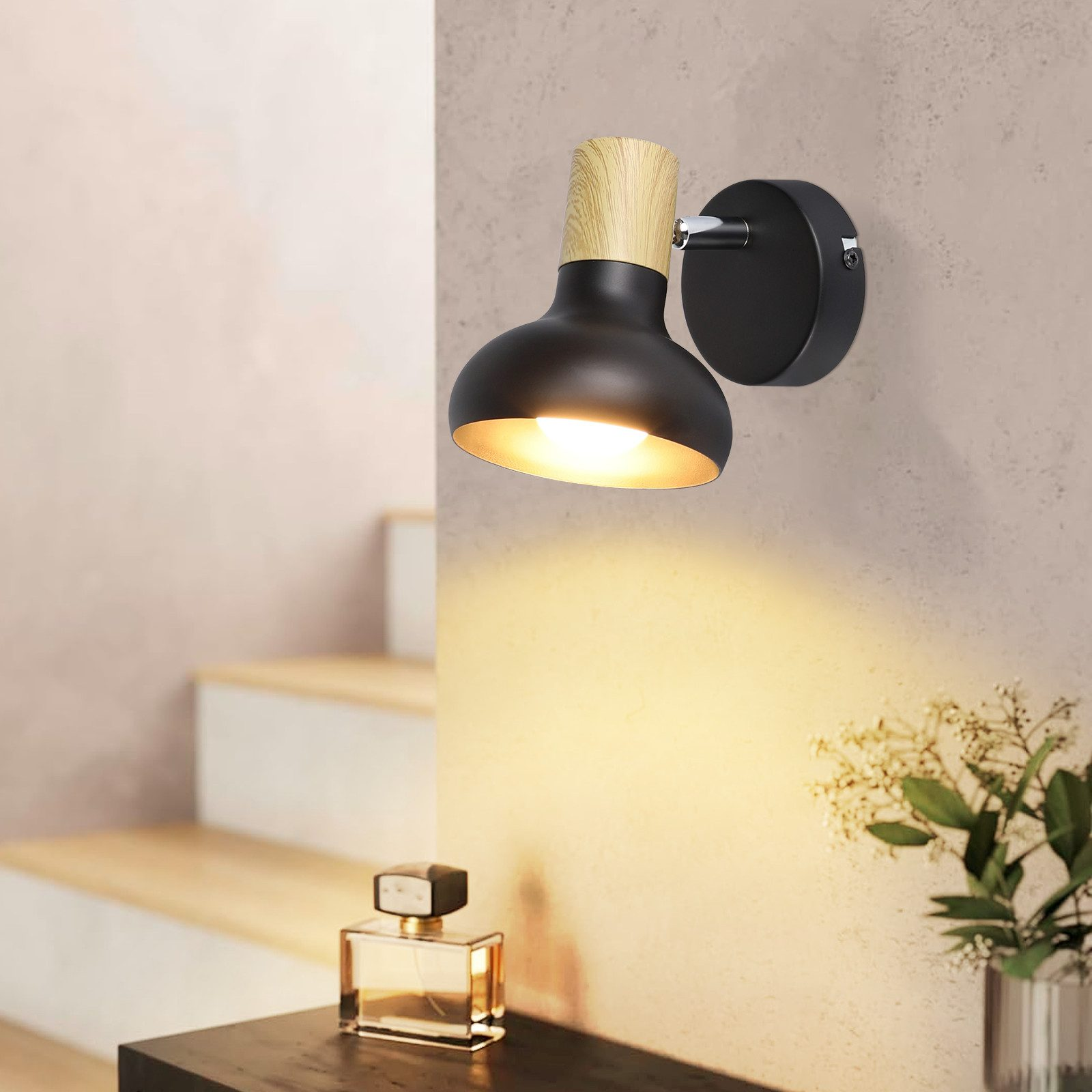Una lampada da parete nera con elementi in legno e una lampadina.