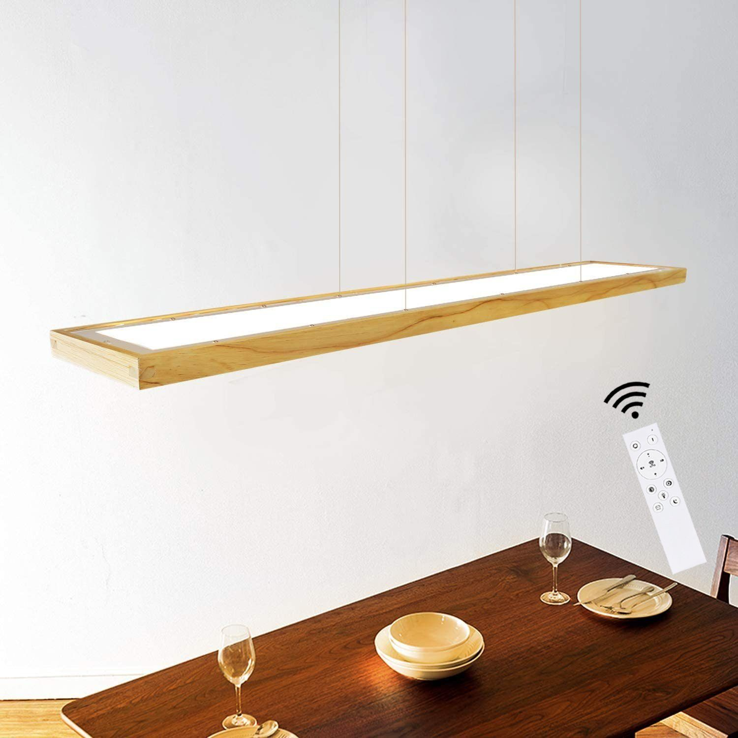 Un'apparecchio di illuminazione in legno appeso sopra un tavolo. Un telecomando e dei bicchieri sono sul tavolo.