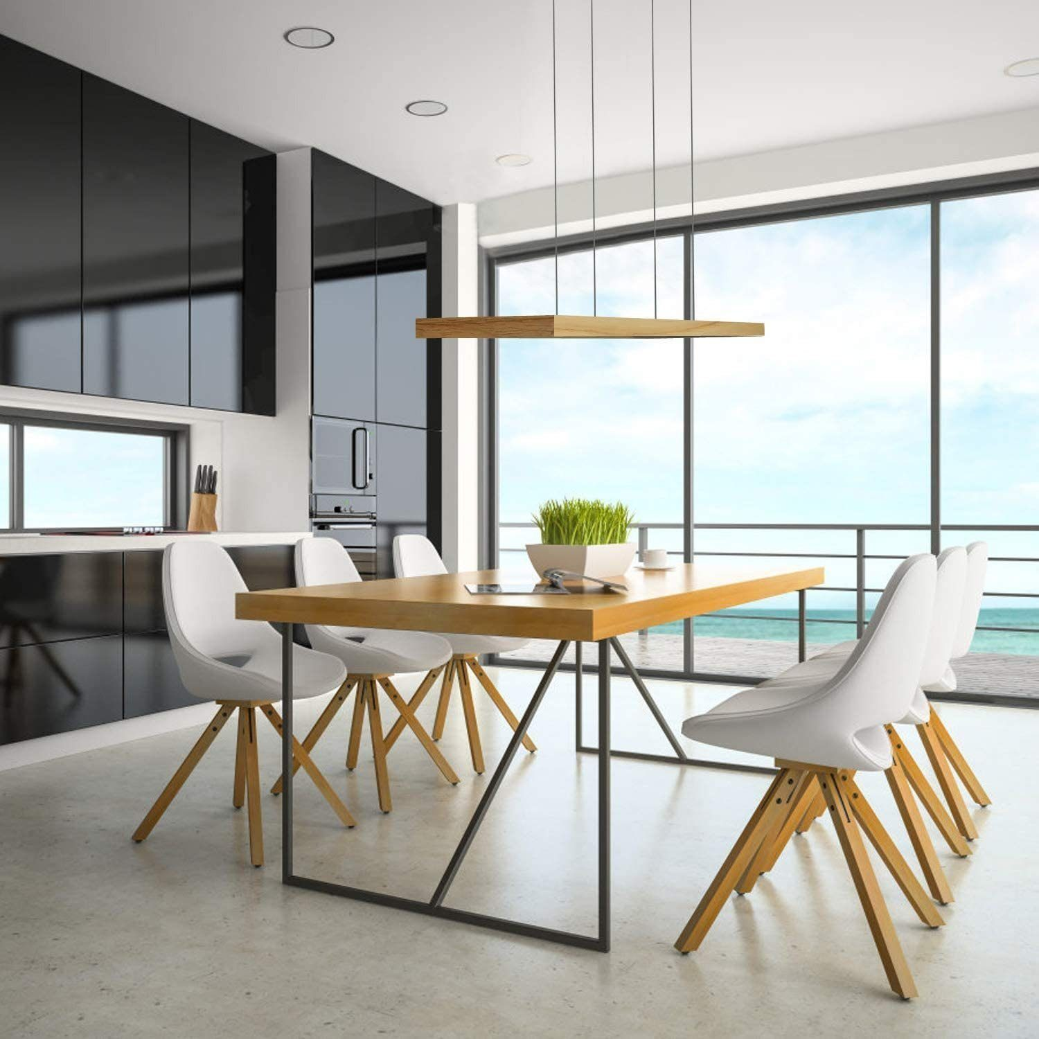 Cucina moderna con tavolo in legno, sedie bianche, mobile cucina nero e vista mare.