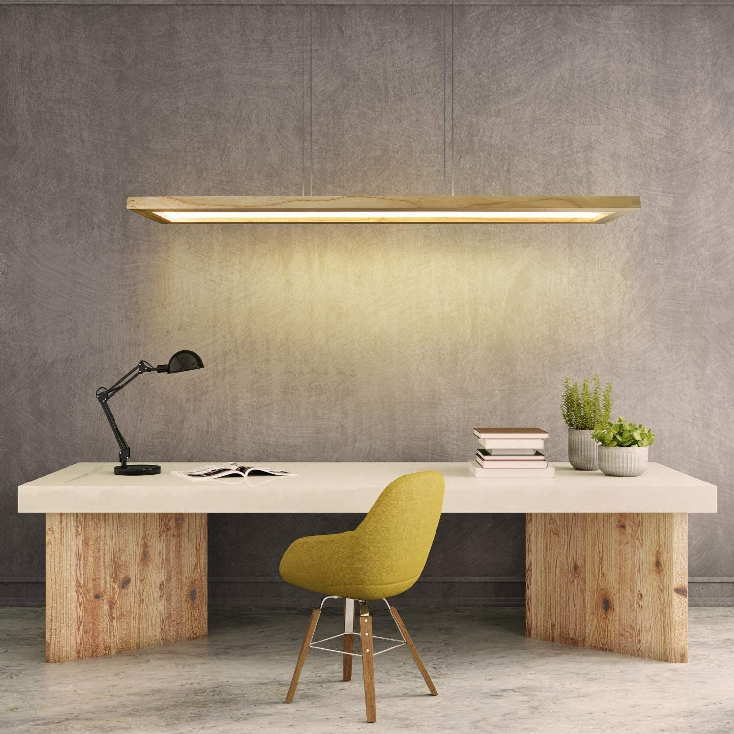 Ufficio: scrivania, lampada, sedia, luce a sospensione. Libri e piante. Parete grigia.