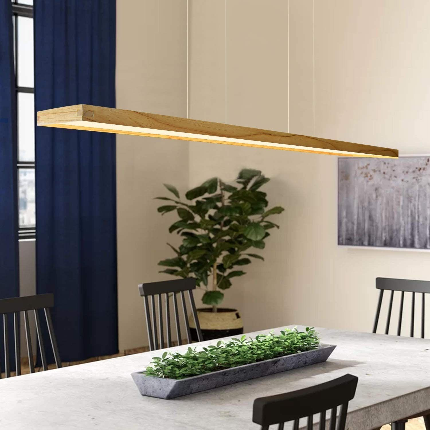Un'apparecchio di illuminazione rettangolare in legno appeso sopra un tavolo con una pianta.