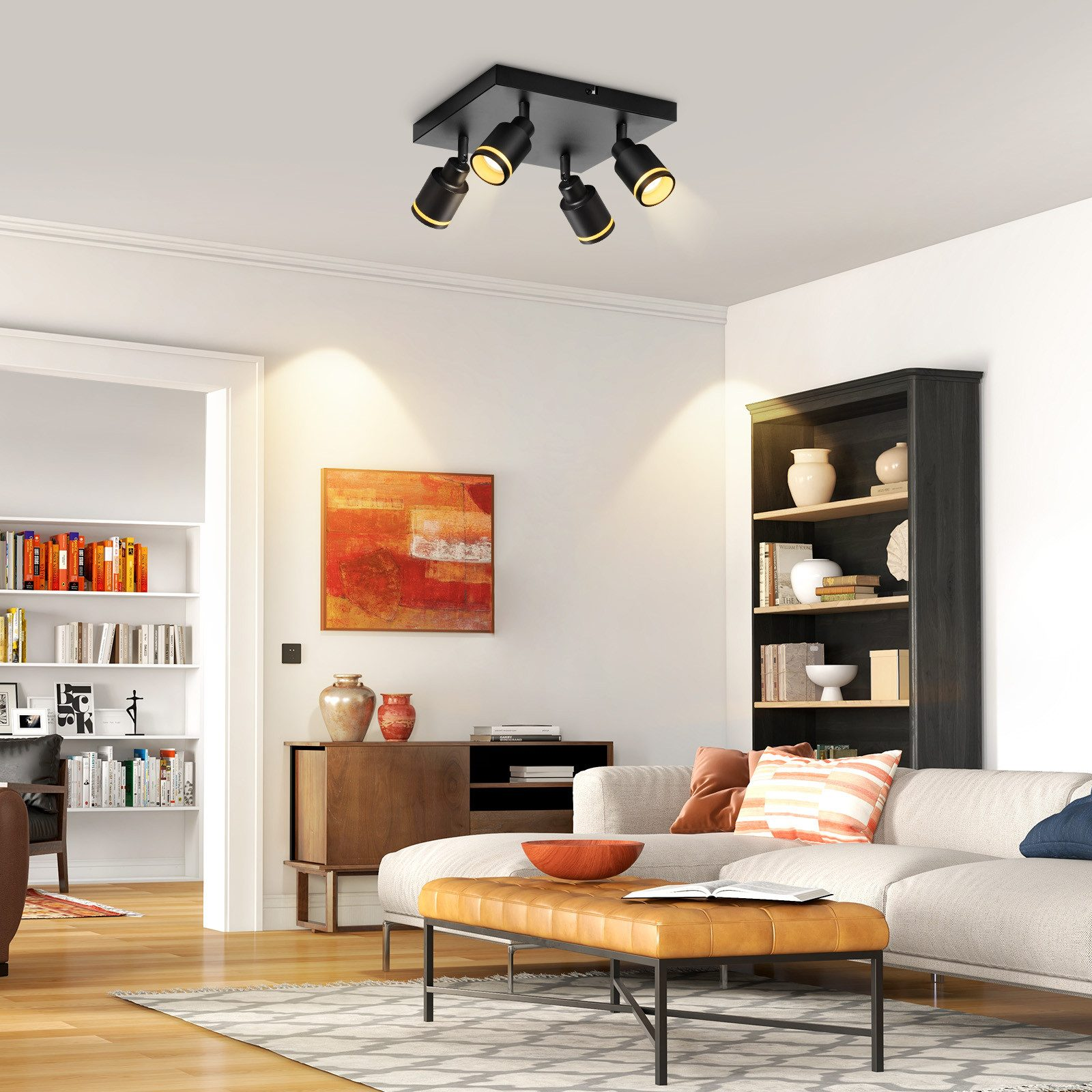 Soggiorno con un apparecchio di illuminazione a soffitto nero. Include un divano, un dipinto e librerie.
