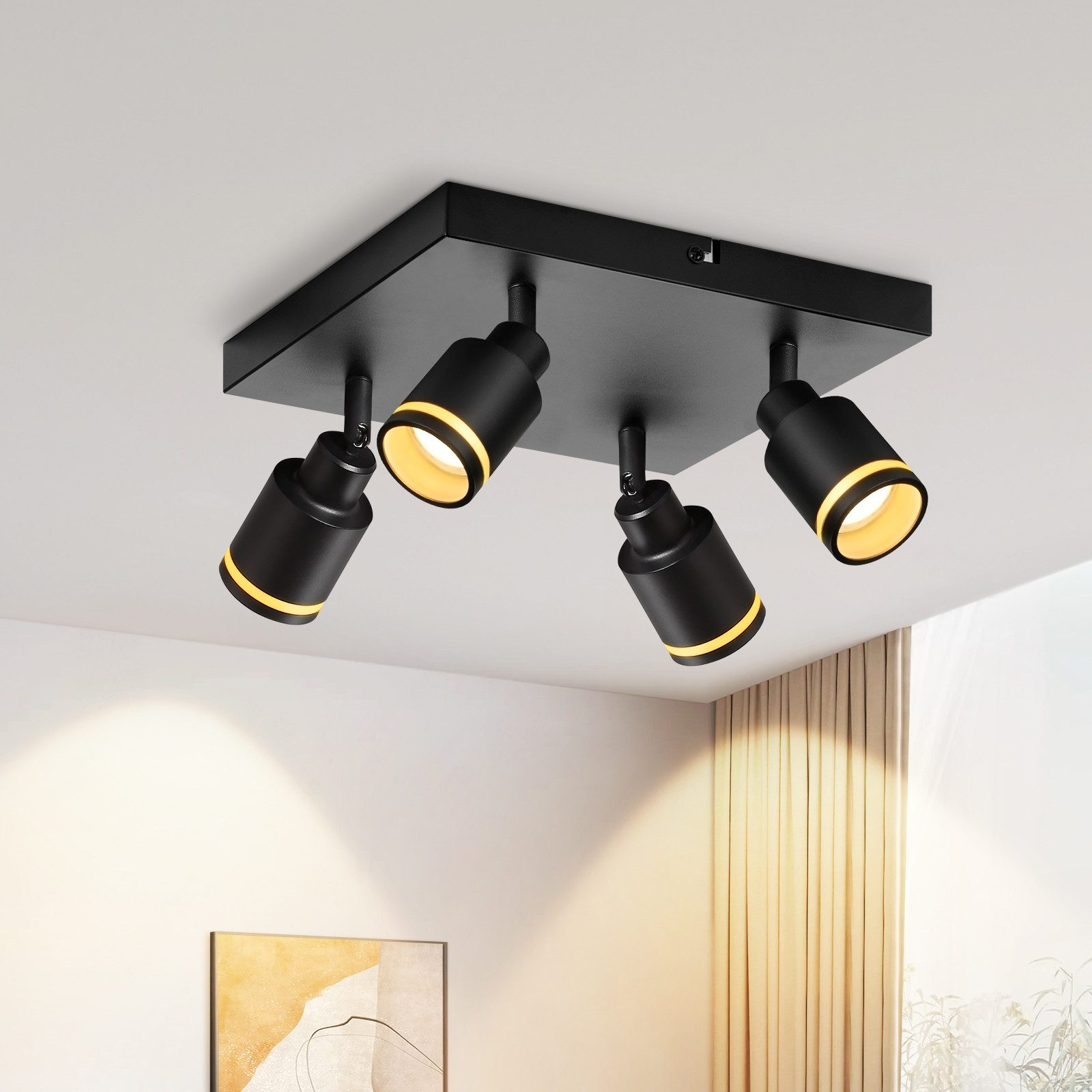 Quattro faretti neri sono montati su un apparecchio a soffitto quadrato. Le luci puntano in direzioni diverse.