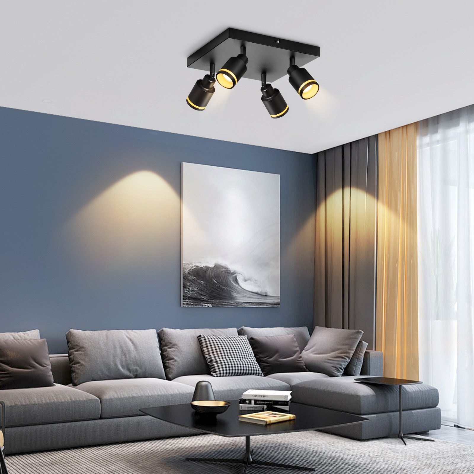 Un moderno soggiorno con un divano grigio, un tavolino e faretti sul soffitto.