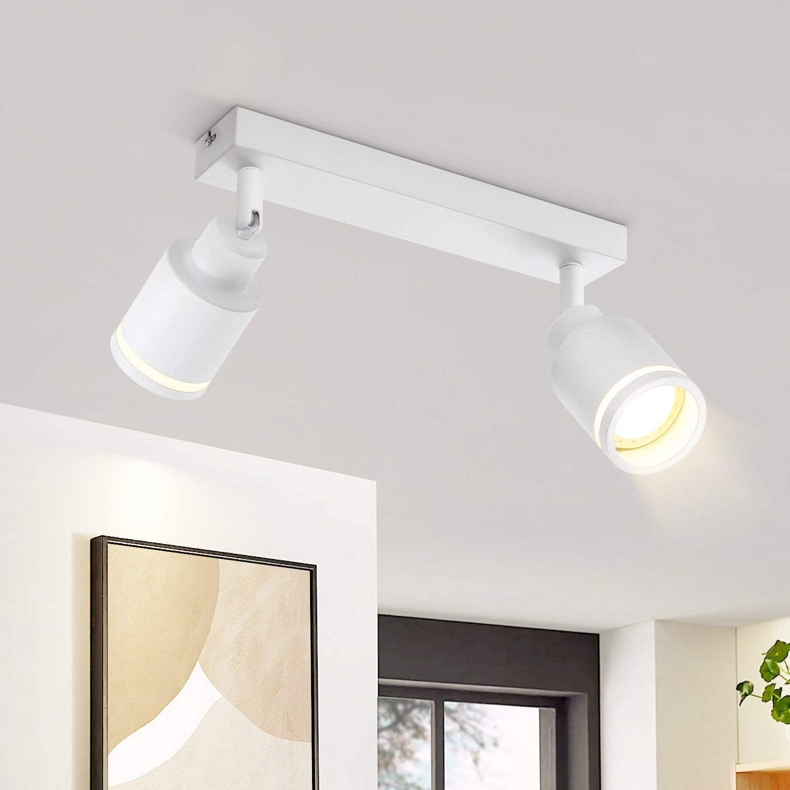 Faretto da soffitto bianco con due teste regolabili. Mostra l'apparecchio in un ambiente moderno.