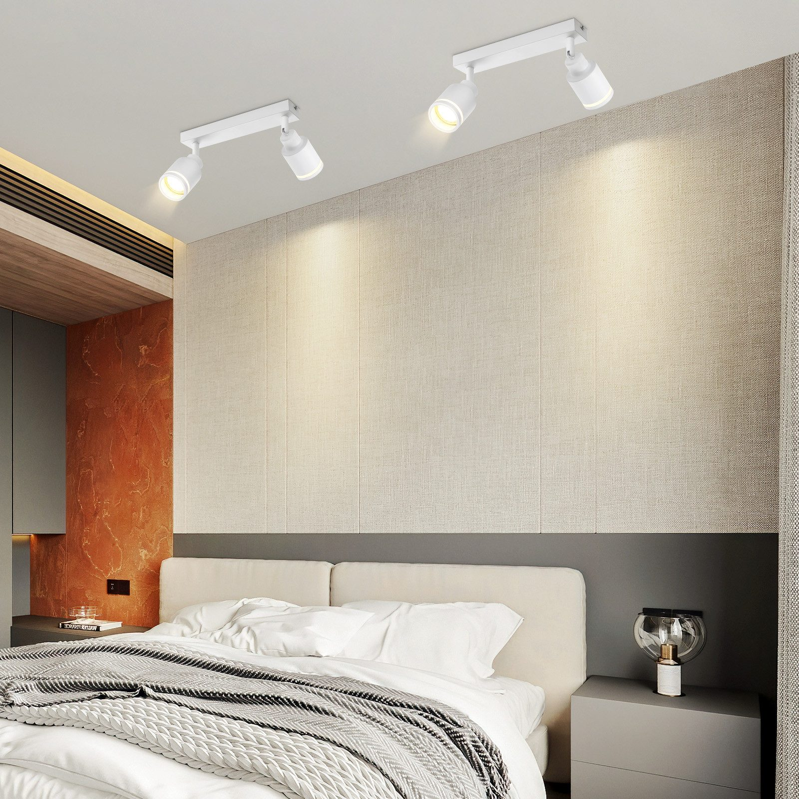 Una camera da letto con due faretti sul soffitto, con un letto e un comodino.