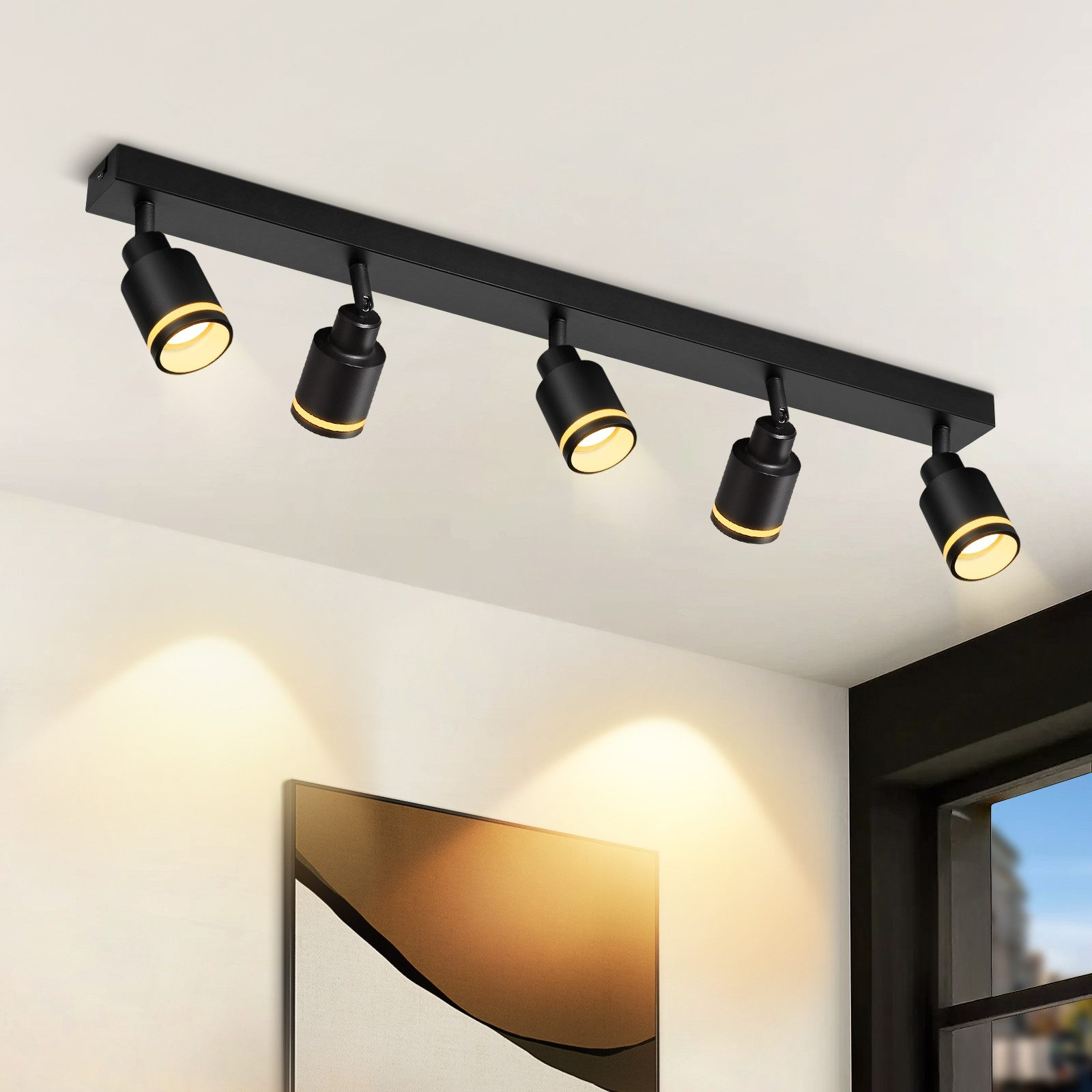 Apparecchio di illuminazione a soffitto nero con cinque faretti. I faretti sono rivolti verso il basso.
