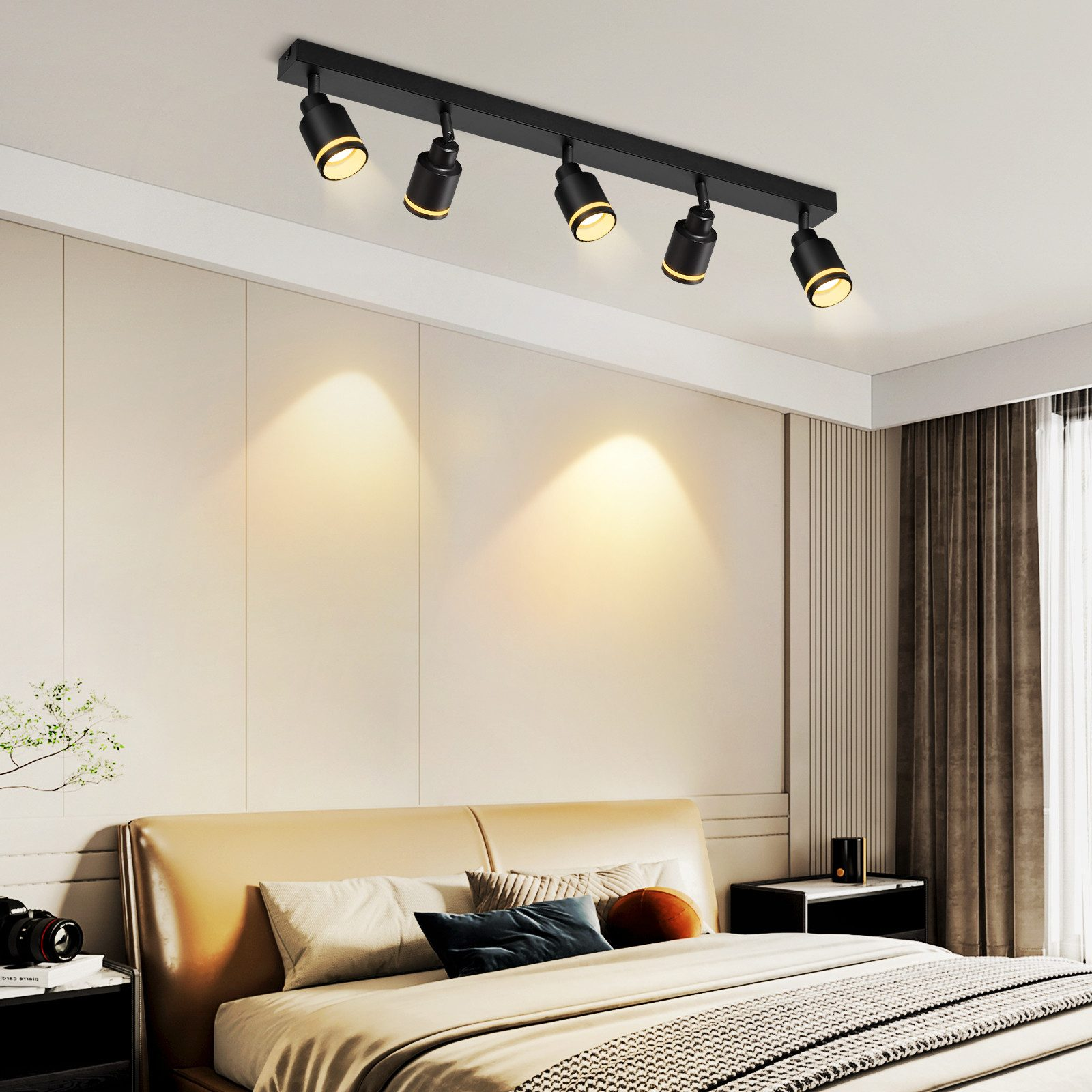 Modernes Schlafzimmer mit Deckenleuchten. Die Leuchten sind schwarz, das Bett hat ein braunes Kopfteil.