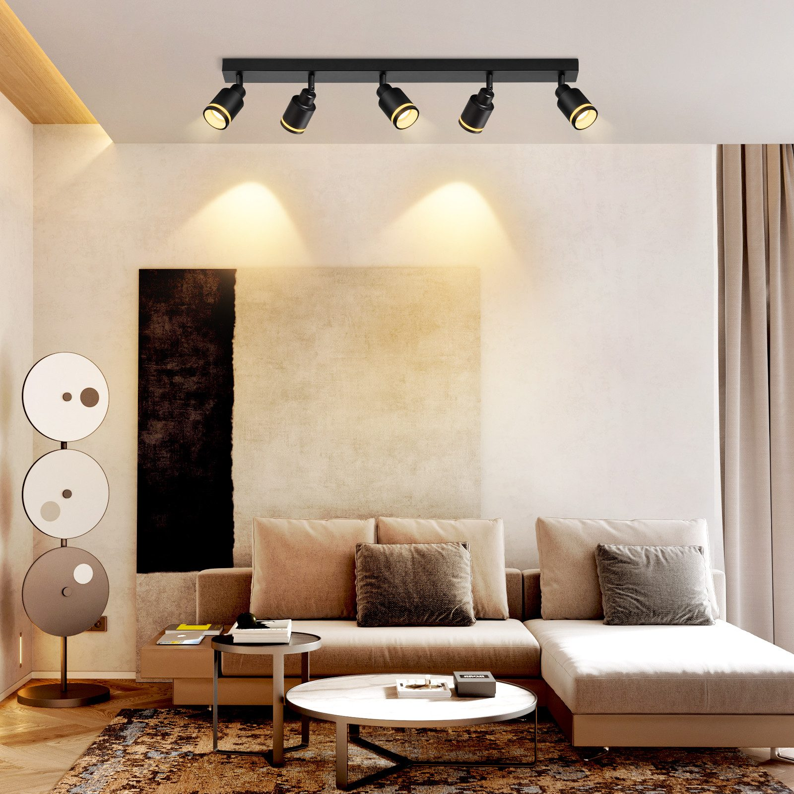 Soggiorno con divano, arte e luci a soffitto. Lampada da terra a sinistra.