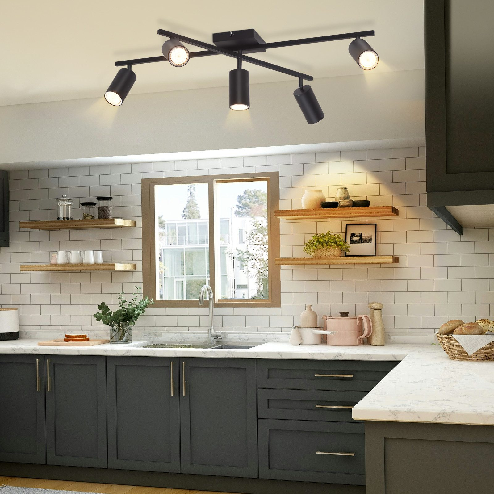 Kuchnia z lampą sufitową i drewnianymi półkami. Ciemne szafki i białe kafelki na ścianie.