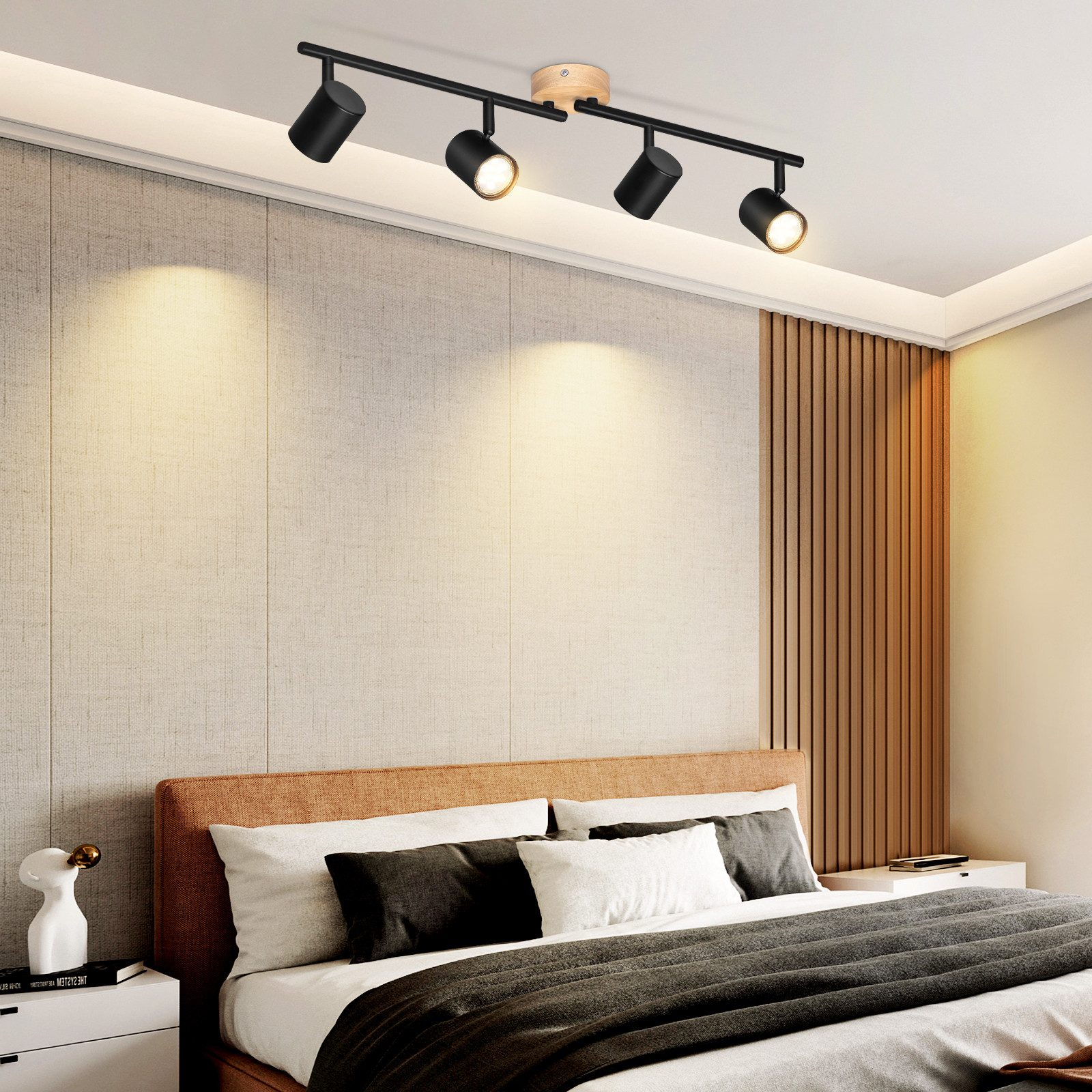Reflektory sufitowe na drewnianej belce nad łóżkiem. Pokój ma neutralną paletę kolorów.